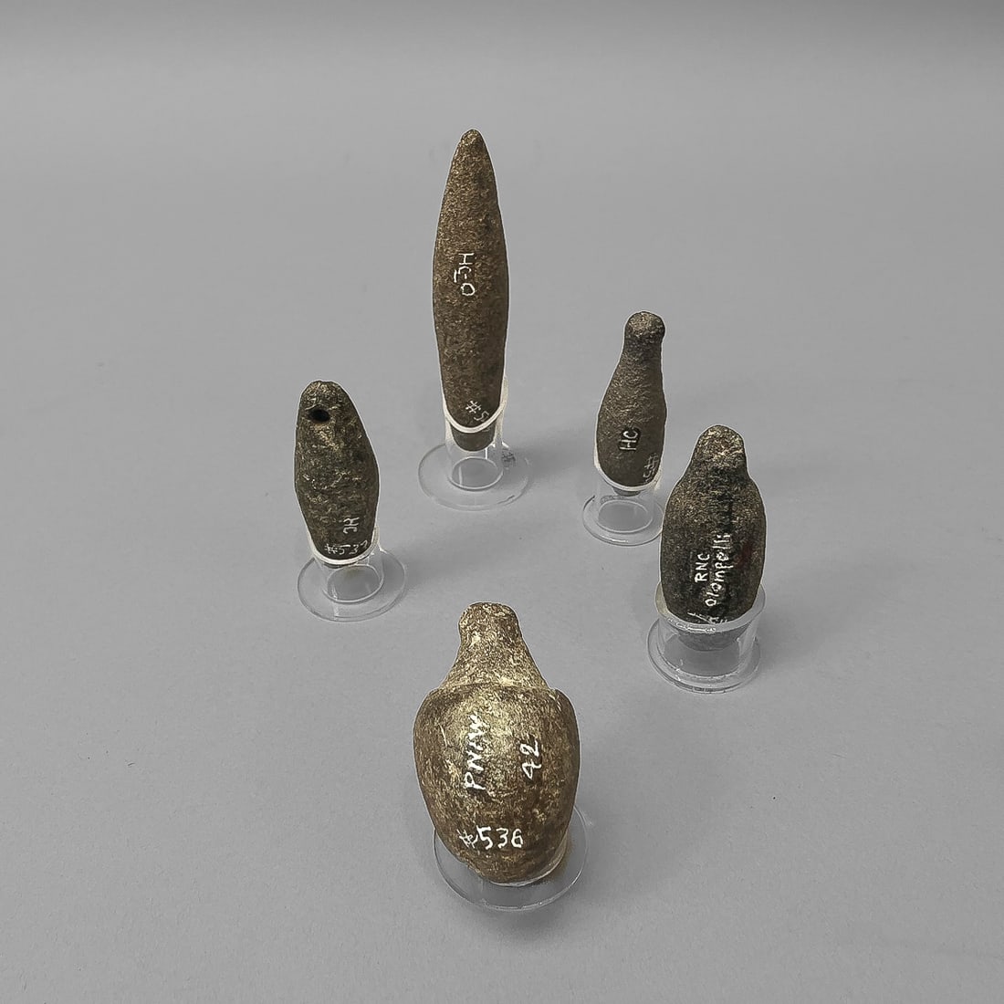 Five Northern California charm stones: Pre-contact period, each with painted inventory and place names, each with Plexi base.