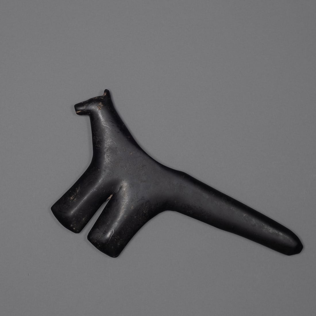 A Northwest Coast hardstone war club: A carved hardstone war club of the "slave killer" type associated with Northwest Coast cultures, worked from a dense dark stone with a naturally lustrous, polished surface consistent with age and