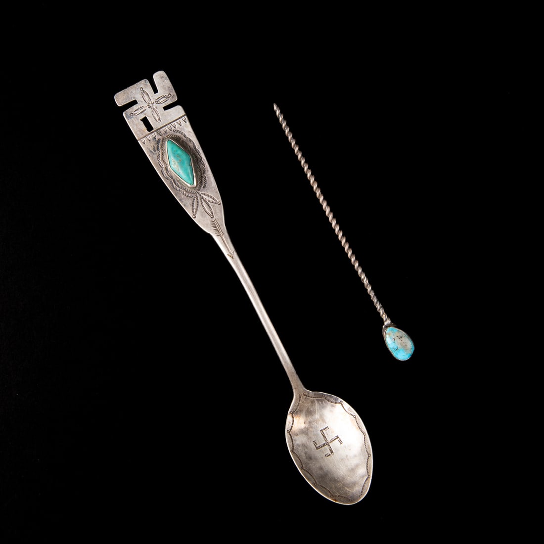 A Navajo manta pin and silver spoon: Hand wrought silver spoon, the scoop decorated with stamp work and whirling log motif, the handle with stamp and chisel work including arrow and whirling log motif with diamond-shaped turquoise