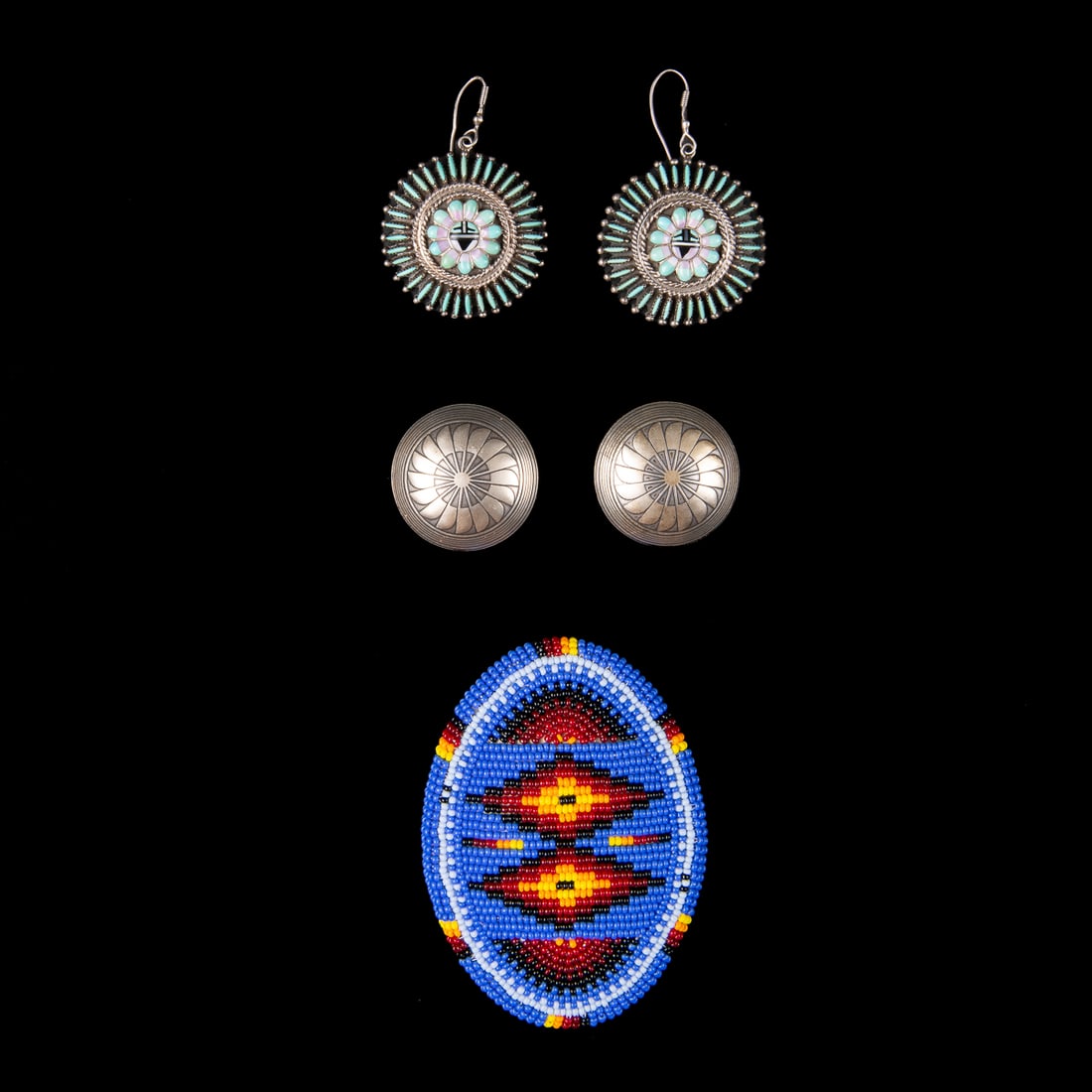 A Southwest beaded buckle and two sets of earrings: The oval buckle, fully beaded on front with leather backing, with a set of sterling silver earrings marked “OTSN” with feather design. Together with a pair of Zuni petit point turquoise earrin
