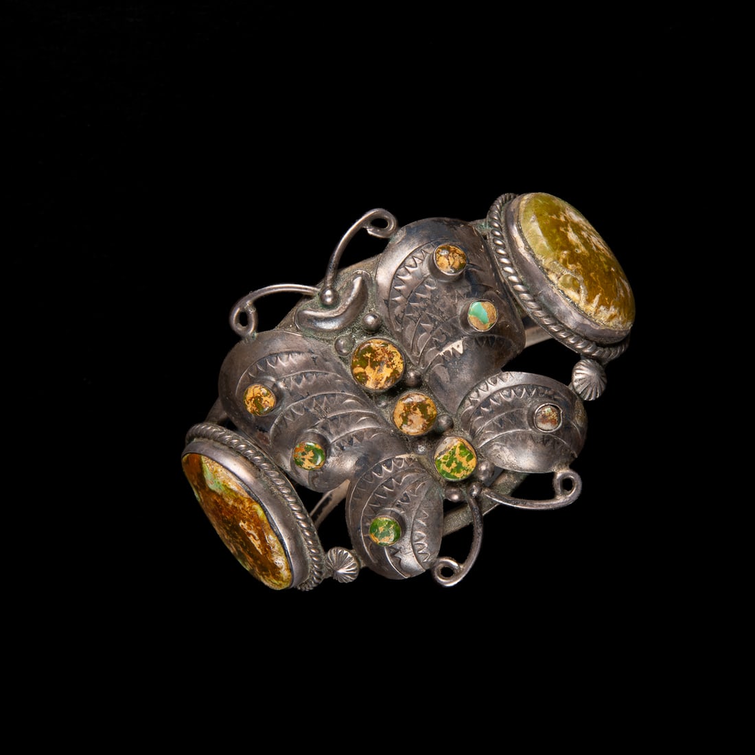 A Southwest silver and turquoise butterfly cuff: A three-wire cuff with two large turquoise settings on each side of a silver butterfly with stamp decoration and multiple turquoise settings. Total interior circumference (including gap) 7, wd. 2, gap