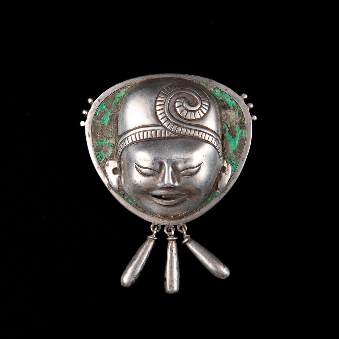 A sterling silver and serpentine brooch by William Spratling, (1 of 2)