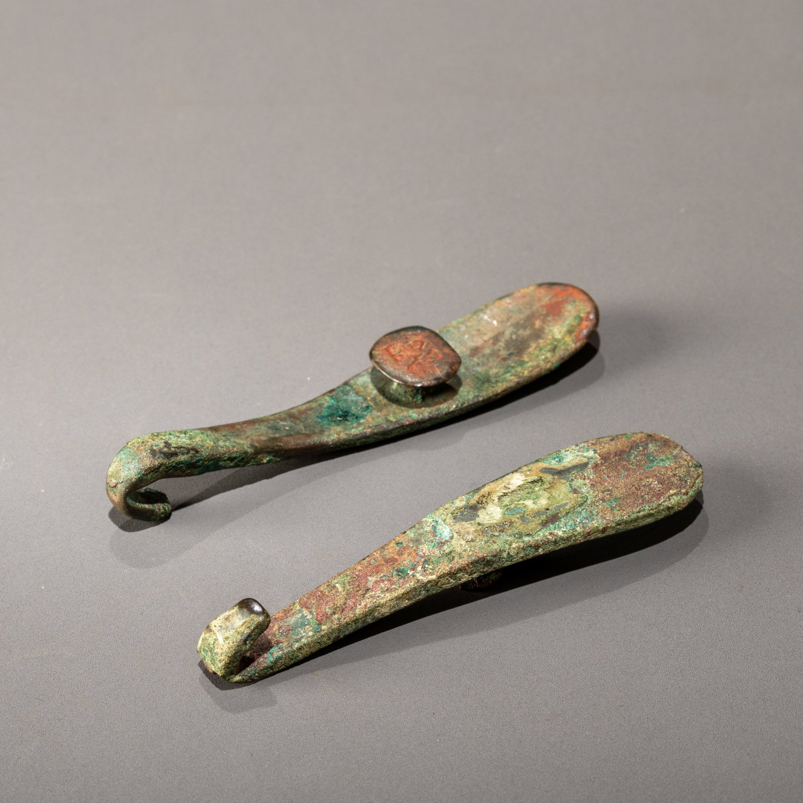 A pair of bronze dragon-head belt hooks with Han Dynasty inscriptions: L: 9.2cm W: 2cm L: 8.8cm W: 2cm
