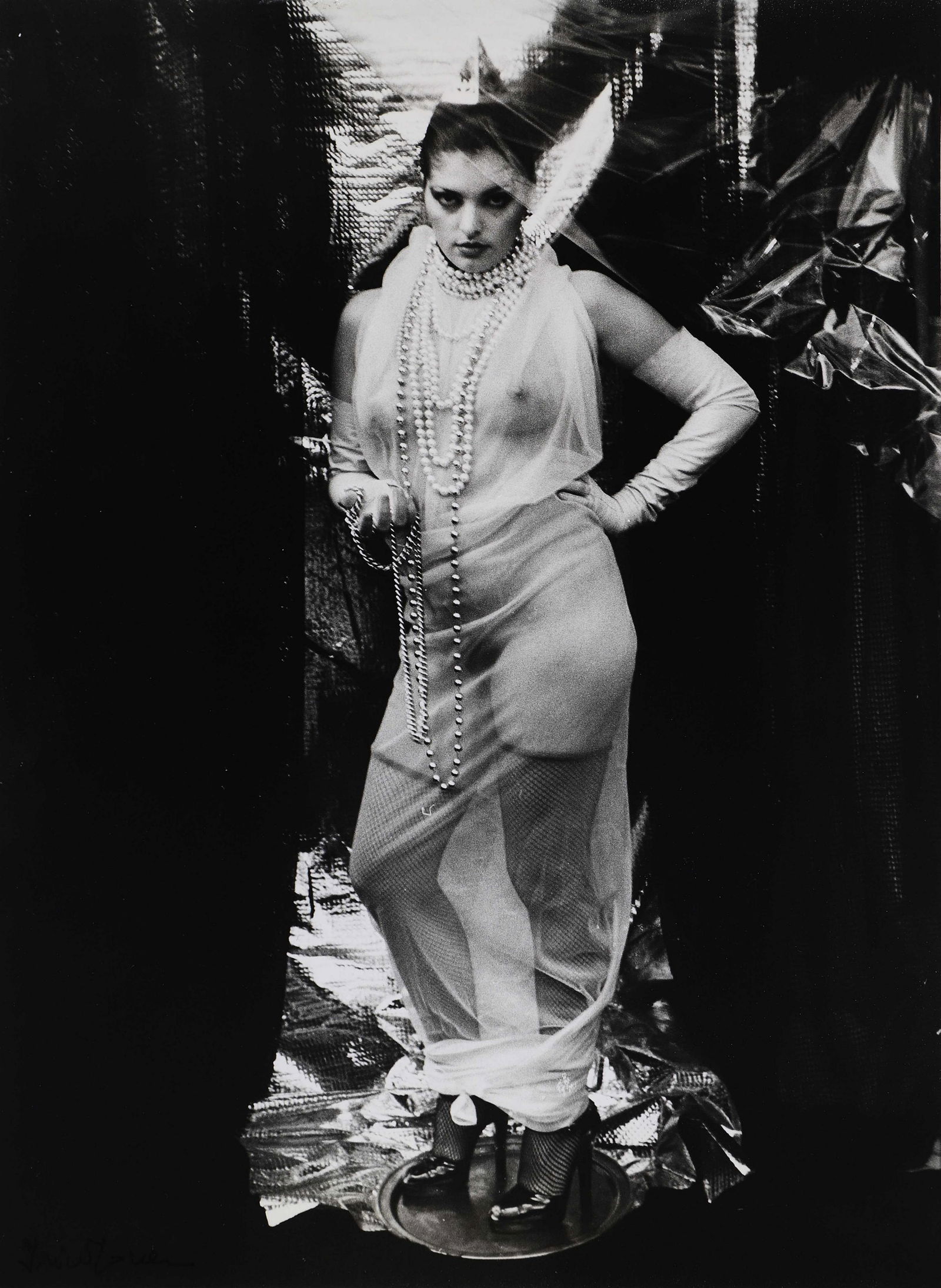 PHOTOGRAPHIES ANCIENNES & MODERNES: Irina IONESCO (1935)Femme aux sautoirs sur un plateau, c.1970Tirage argentique d’époque, signé à l’encre en bas à gauche et au verso.Dimensions : 40 x 30 cm