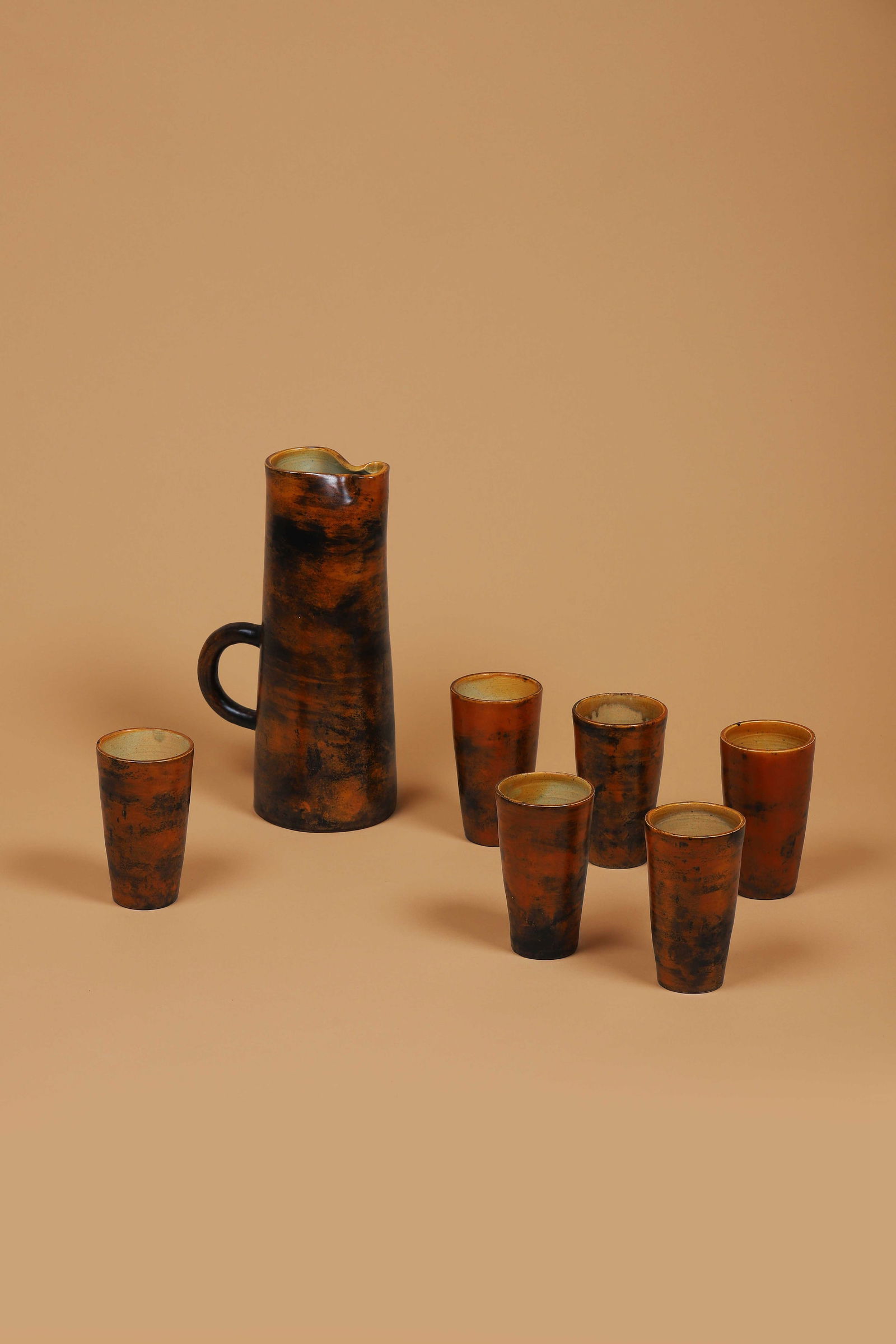 Jacques BLIN (1920-1995): Service comprenant un pichet et six gobelets En céramique émaillée brune et noire Signés JBlin sous la base H. : 28 cm. H. : 12.5 cm. Circa 1955