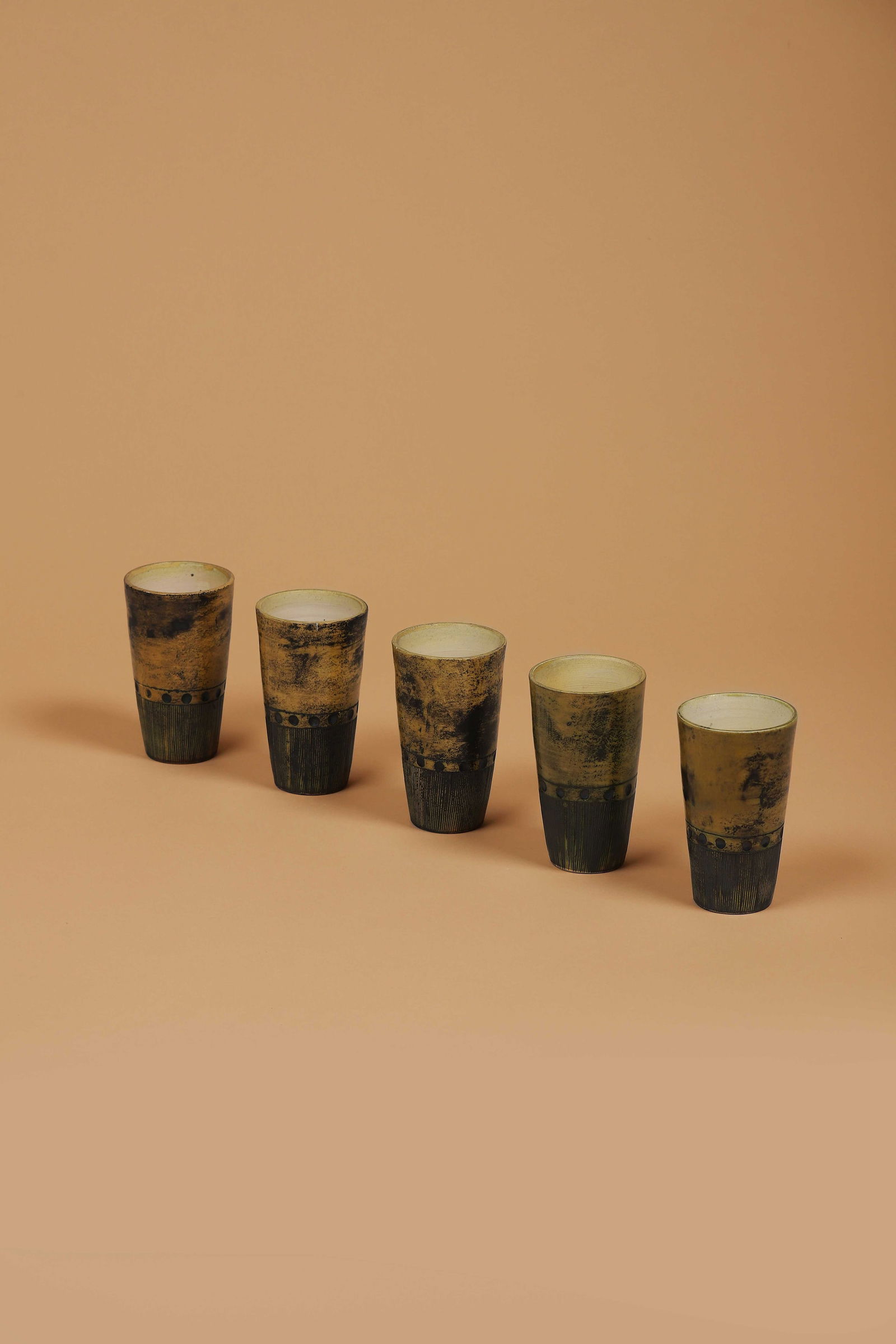 Jacques BLIN (1920-1995): Suite de cinq gobelets En céramique émaillée jaune et noire Signés JBlin sous cinq bases H. : 12 cm. Circa 1955