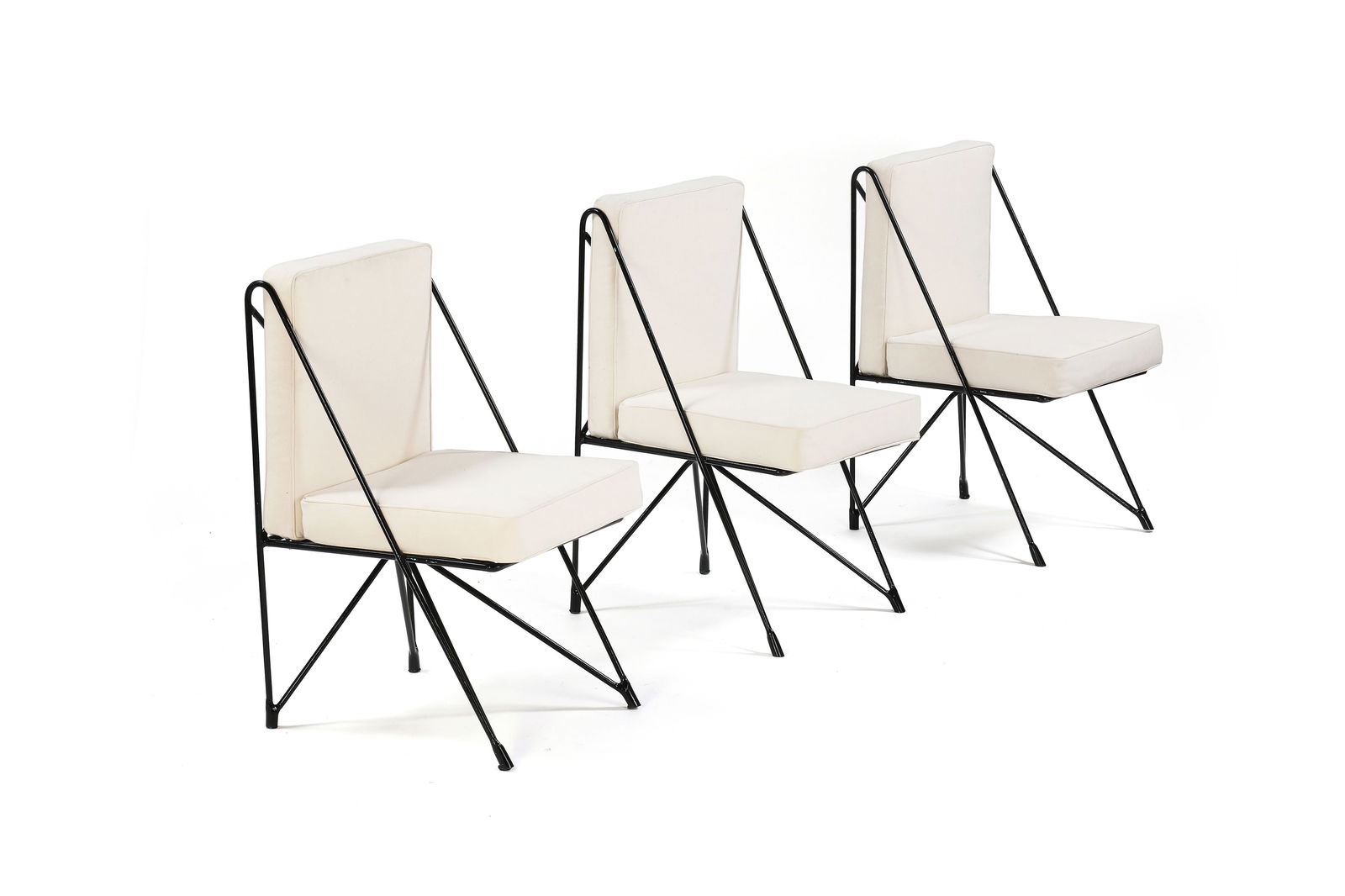 Raoul GUYS (XX)Suite de quatre chaises à structure en métal tubulaire relaqué noir: Raoul GUYS (XX)Suite de quatre chaises à structure en métal tubulaire relaqué noir formant le piètement, coussins d’assises et de dossiers en toile de coton blanc.H. : 89 cm.