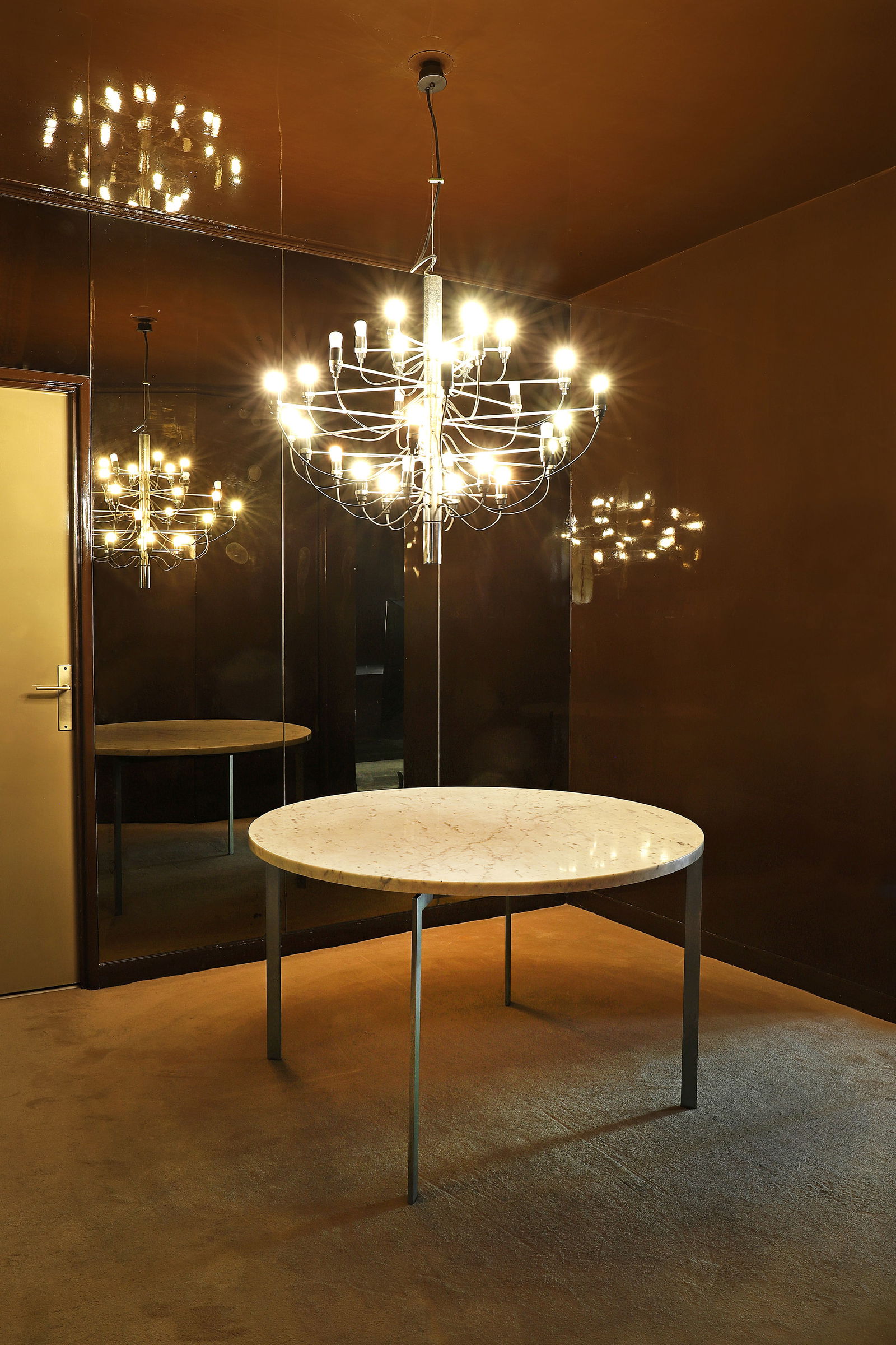 Jacques DUMOND (1906-1988)Table de salle à manger à plateau circulaire en marbre blanc: Jacques DUMOND (1906-1988)Table de salle à manger à plateau circulaire en marbre blanc veiné gris disposé sur une structure en lames d’acier poli formant le piètement.H.