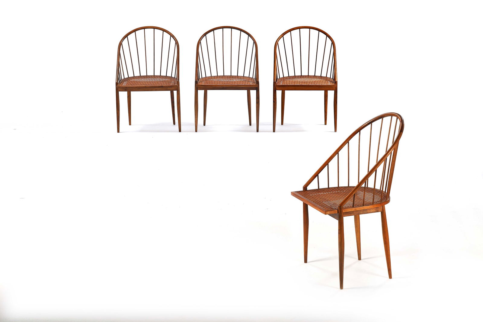 Joaquim TENREIRO (1906-1992) Suite de quatre chaises modÃ¨le Cadeira curva, circa 1950, en: Joaquim TENREIRO (1906-1992) Suite de quatre chaises modÃ¨le Cadeira curva, circa 1950, en imbuia Ã dossier corbeille amÃ©nagÃ© de barreaux et assise cannÃ