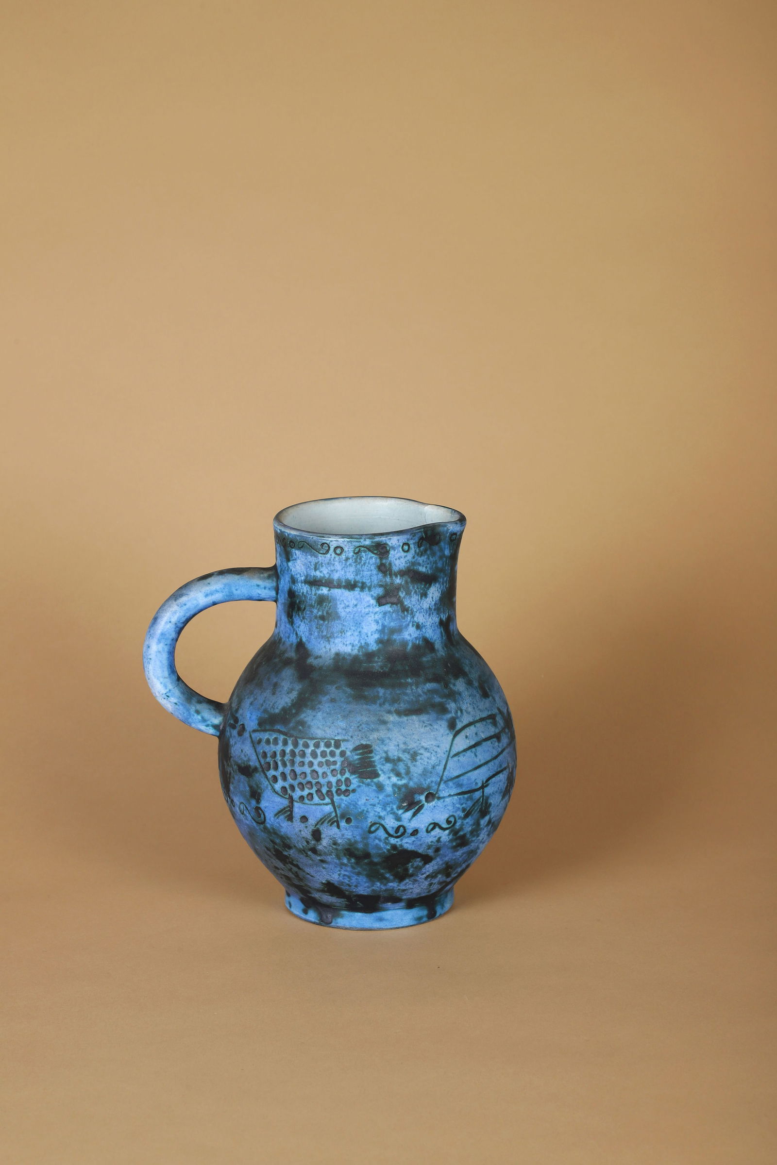 Jacques BLIN (1920-1995): Pichet à anseÉpreuve céramique émaillée bleu et noir à décord’animaux stylisésSigné J Blin sur l’enversH. : 21 cm.