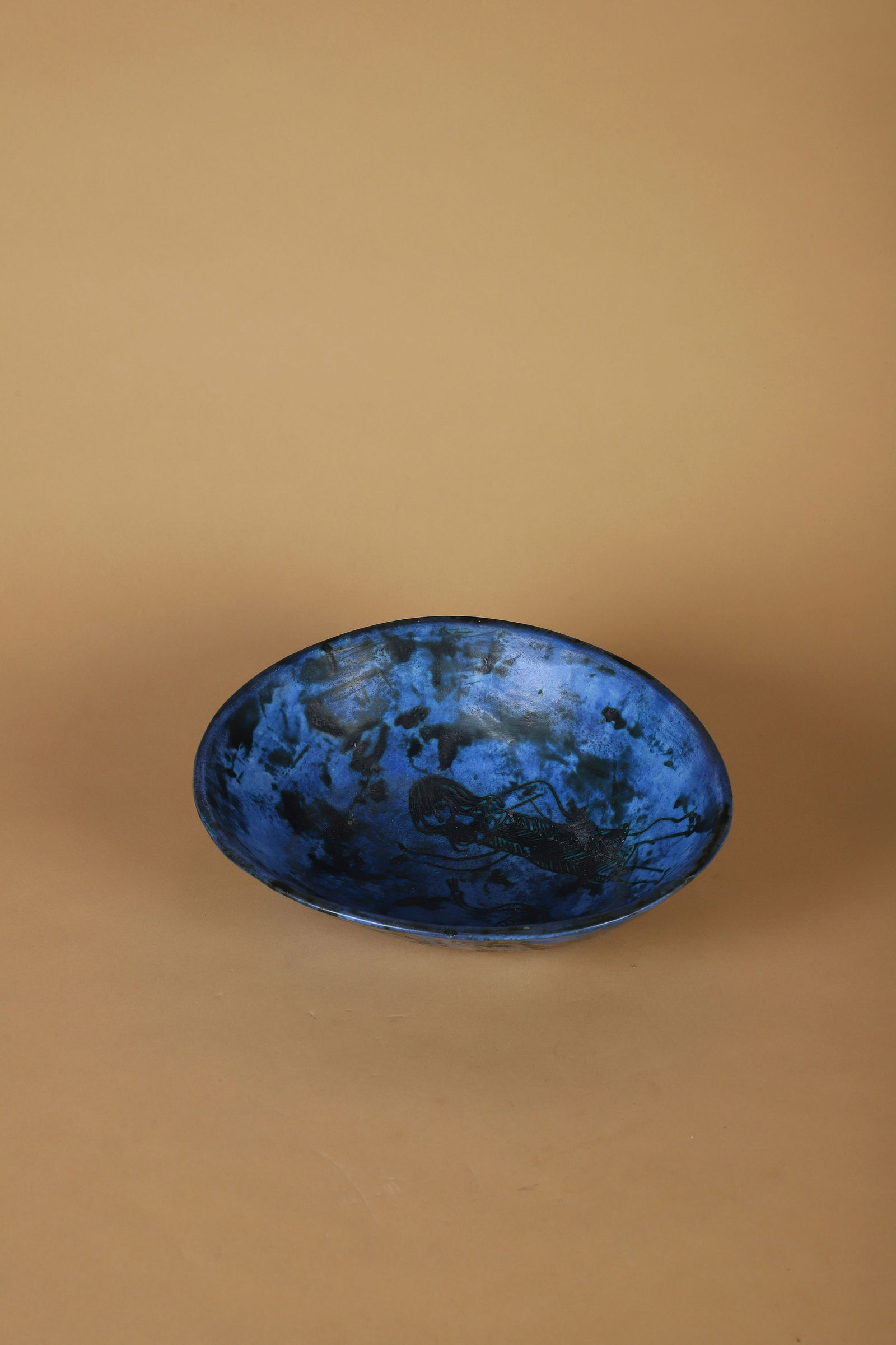 Jacques BLIN (1920-1995): Coupe Épreuve en céramique émaillée bleu et noir à décor d’une femme et d’un oiseau Signé J Blin sur l’envers H. : 9 cm - L. : 26 cm. - P