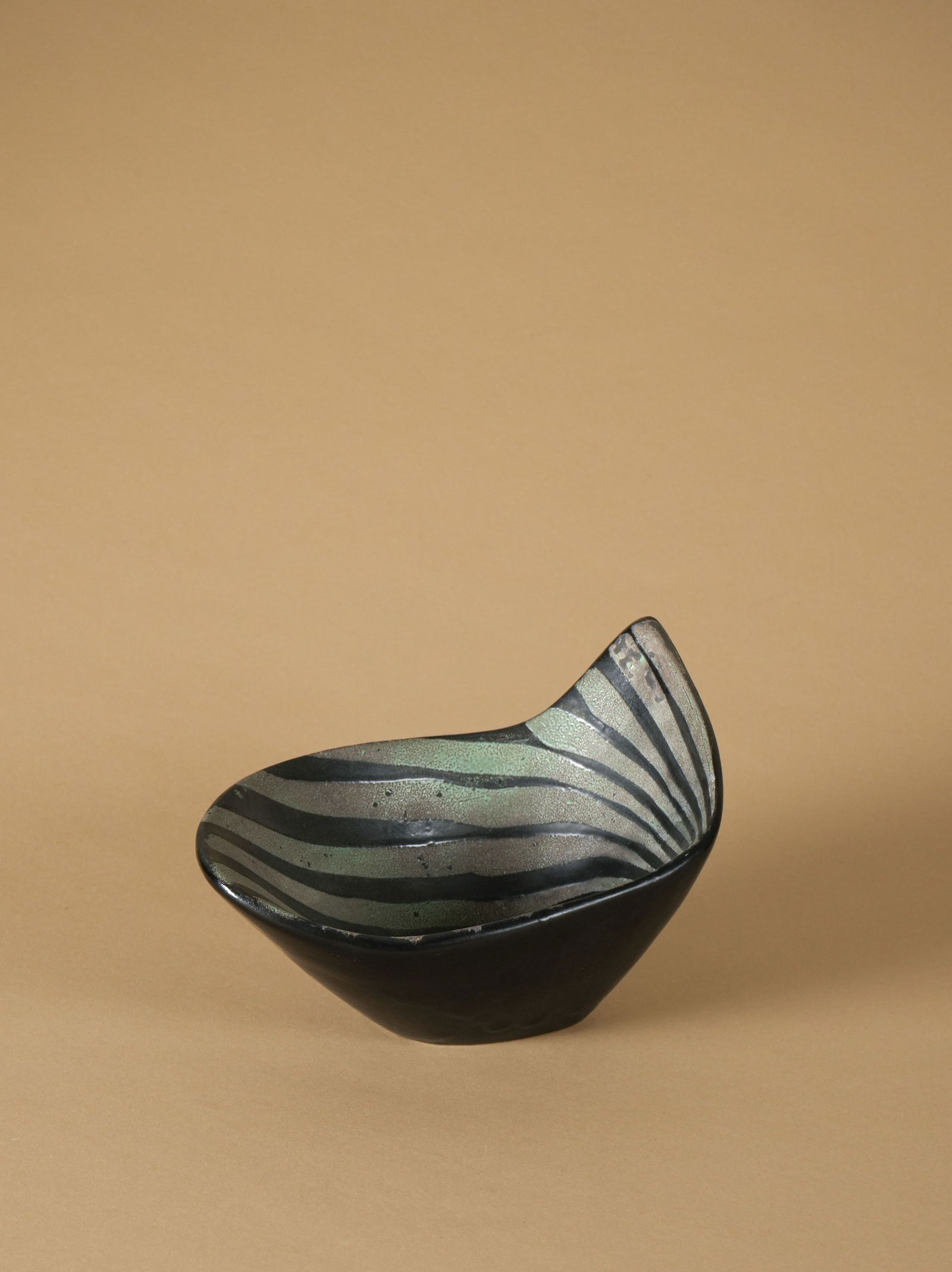 Roger CAPRON (1922-2006): Coupe modèle Marine n° 2, 1953Épreuve en faïence émaillée noir et vertà décor de rayuresSigné Capron et situé Vallauris France sur l’enversH. :