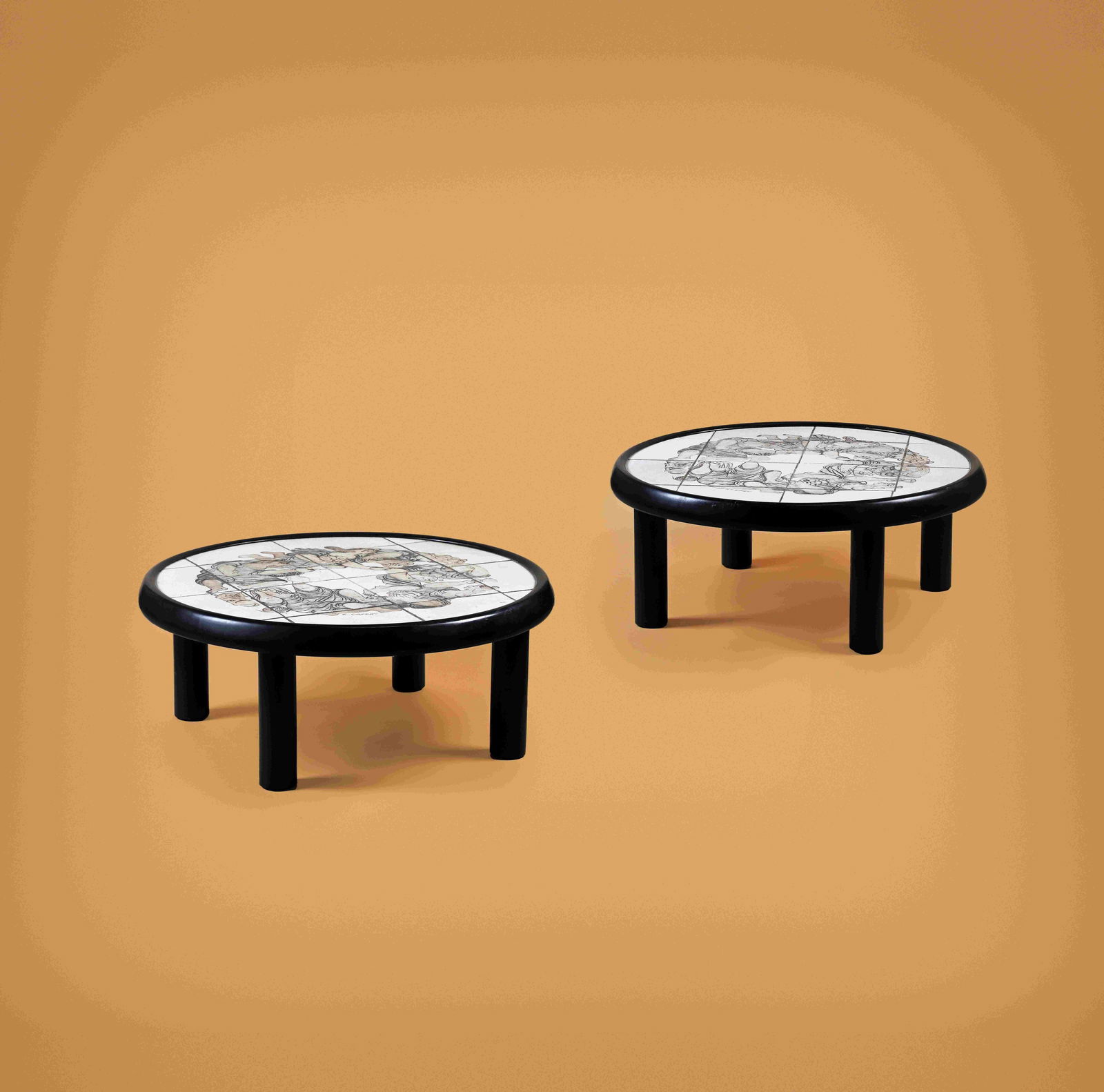 Roger CAPRON (1922-2006): Suite de deux tables basses, 1981, à plateau en céramiqueémaillée à décor guirlande de femmes et d’un chatdisposé sur une structure en bois reposant sur quatre