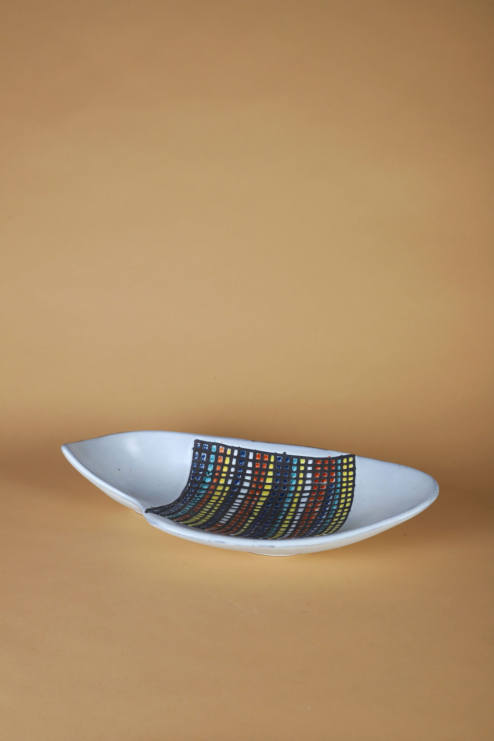 Roger CAPRON (1922-2006): Coupe marine n° 1, circa 1957Épreuve en faïence émaillée blanc à décorquadrillé multicoloreSignée Capron, marqué NII et situé Vallaurissur l̵