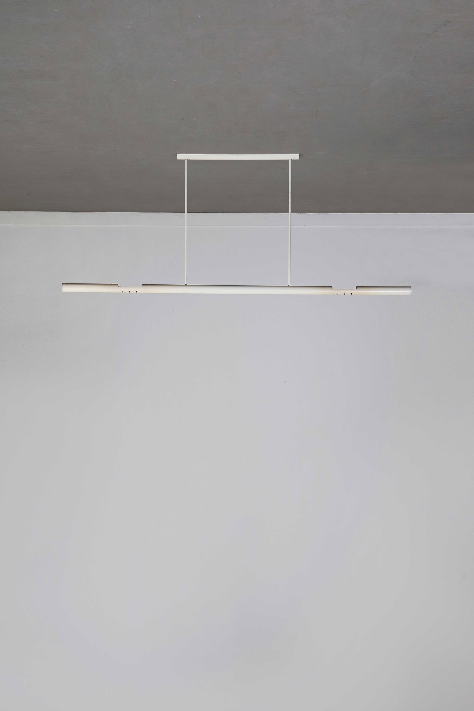Alain RICHARD (1926-2017): Grande suspension modèle n°8282, circa 1975, à structure tubulaire en métal laqué blanc et à éclairage halogène.H. : 100 cm. - L. 200 cm.Edition Disderot