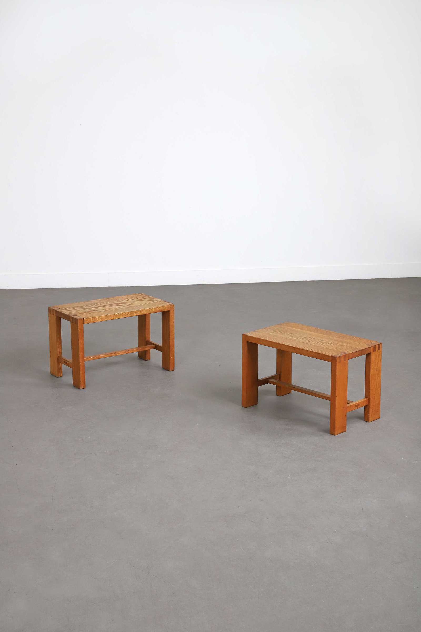 Pierre CHAPO (1927-1986): Suite de deux bouts de canapés, circa 1980, en orme, à plateau rectangulaire, reposant sur un piètement quadripode joint par une entretoise en partie basse. H. : 35 cm. - L. : 55 cm. -