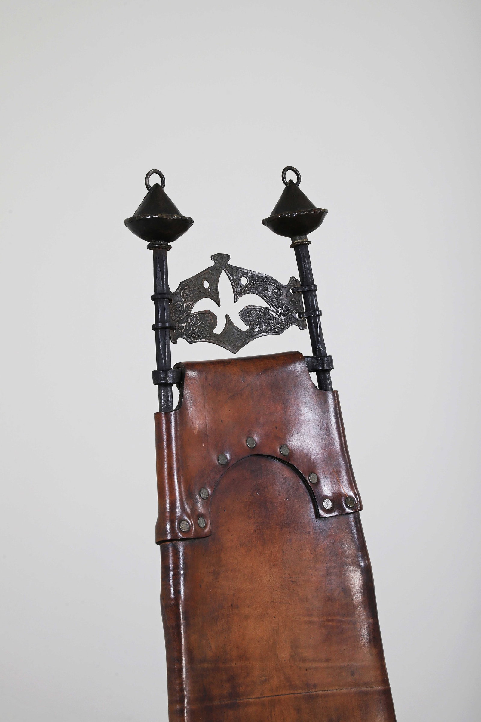 François (1931-2016) et Sido THEVENIN (1934-1986): Suite de deux chaises, circa 1975 à haut dossier se prolongeant en assise tendus en cuir havane patiné disposés sur une structure métal et fer laqué noir, revêtement en c