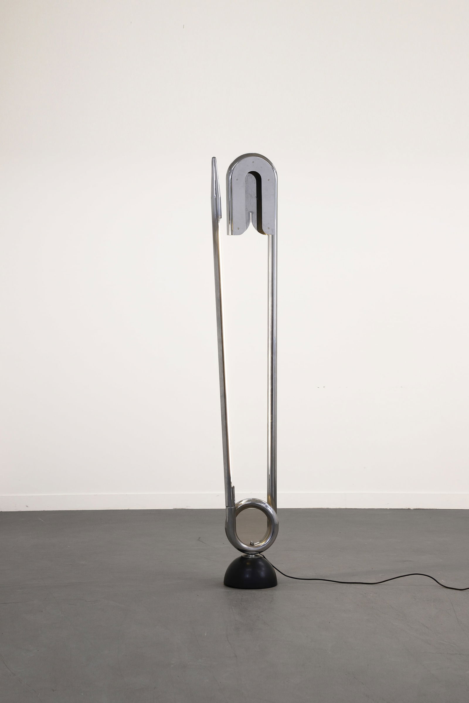 Yonel LEBOVICI (1937-1998): Yonel LEBOVICI (1937-1998)Lampadaire modèle Épingle de nourrice, circa 1980, en acier chromé, à éclairage fluorescent incorporé le long de la pointe et reposant sur un so