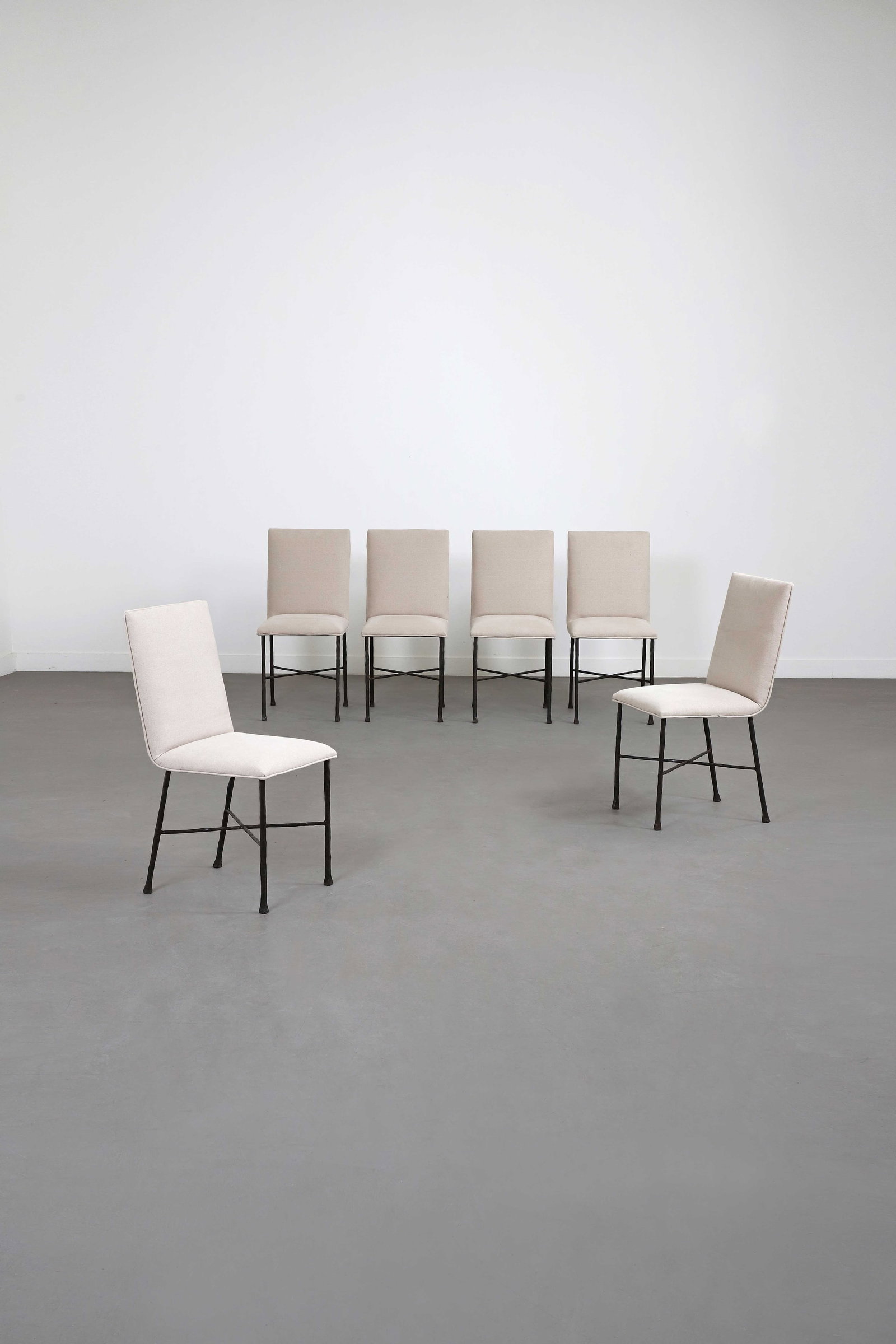Elizabeth GAROUSTE (1949) & Mattia BONETTI (1953): Suite de six chaises, circa 1990, à assise et dossier garnis d’une toile de coton sable, disposées sur une structure en fer battu patiné formant un piètement quadripode joint