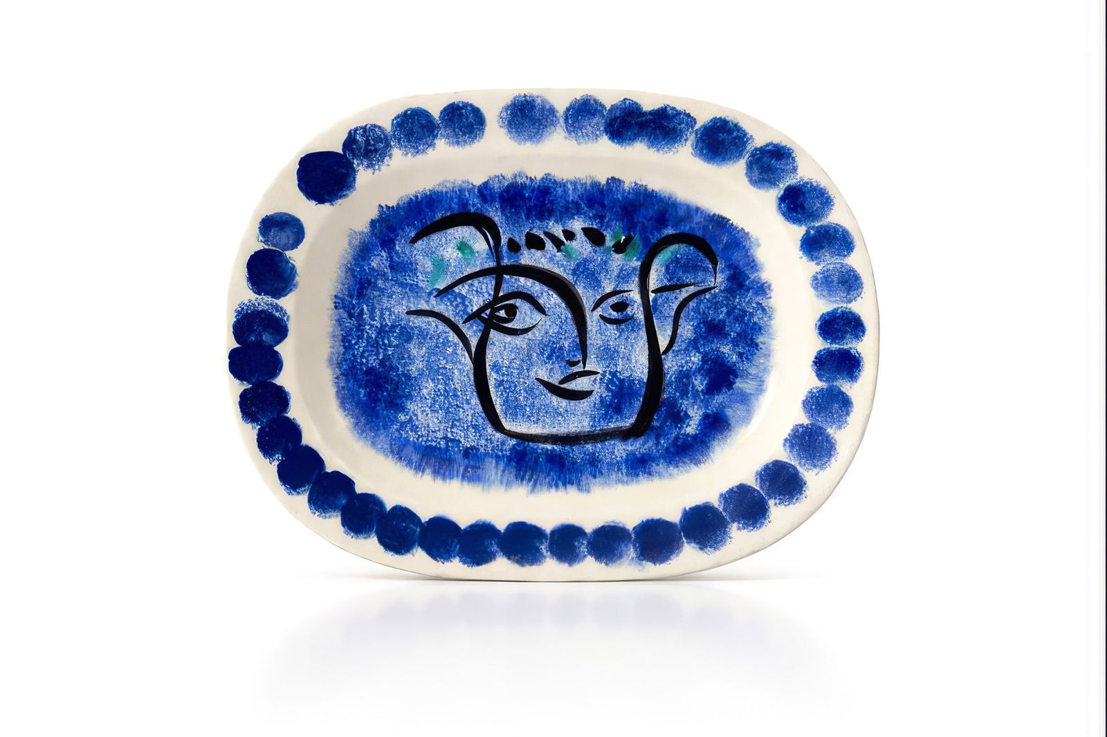 Pablo PICASSO (1881-1973): Plat dit au Visage noir moucheté, circa 1948Épreuve en terre de faïence blanche, décor aux engobes bleu, noir et turquoisePorte les cachets Madoura plein feu et Edition Picasso, ma
