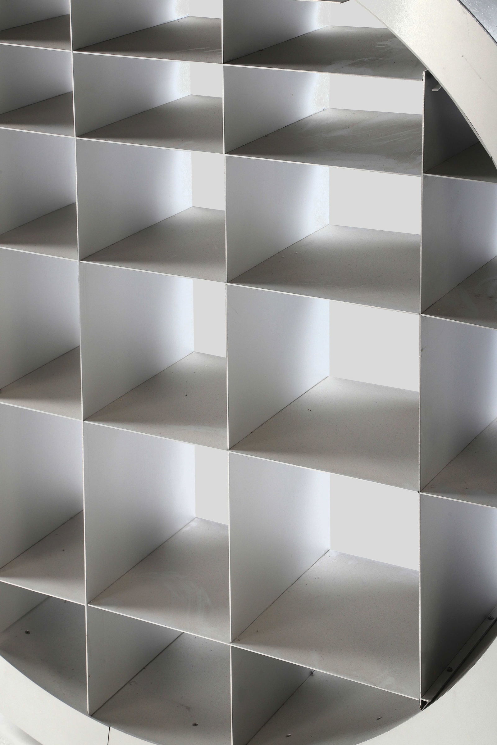 Ron ARAD (1951)`: Bibliothèque modèle Reinventing the Wheel, 2000, en acier inoxydable, à bâti circulaire aménagé d'un enchevêtrement de lames verticales et horizontales formant des n