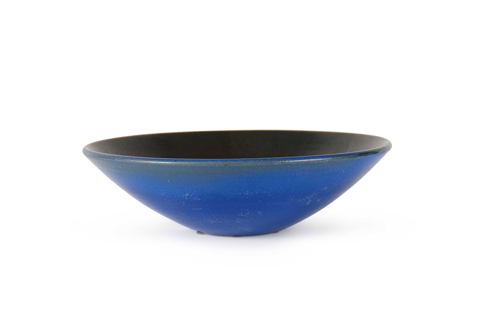 ATELIER MADOURA (1938-1997): Large coupe creuse sur talonÉpreuve en céramique émaillée noir à l’intérieur et bleu à l’extérieur à décor de poissons Porte le cachet