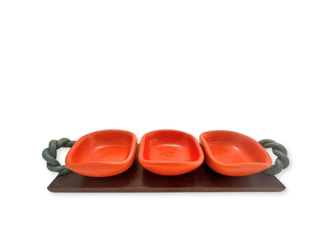 TRAVAIL FRANÇAIS (XX): Plateau rectangulaire à double anse en chêne recevant trois ramequins en céramique émaillée orange de Pol ChambostMarqué Made in France sur l'enversH. : 8 cm. - L. : 52