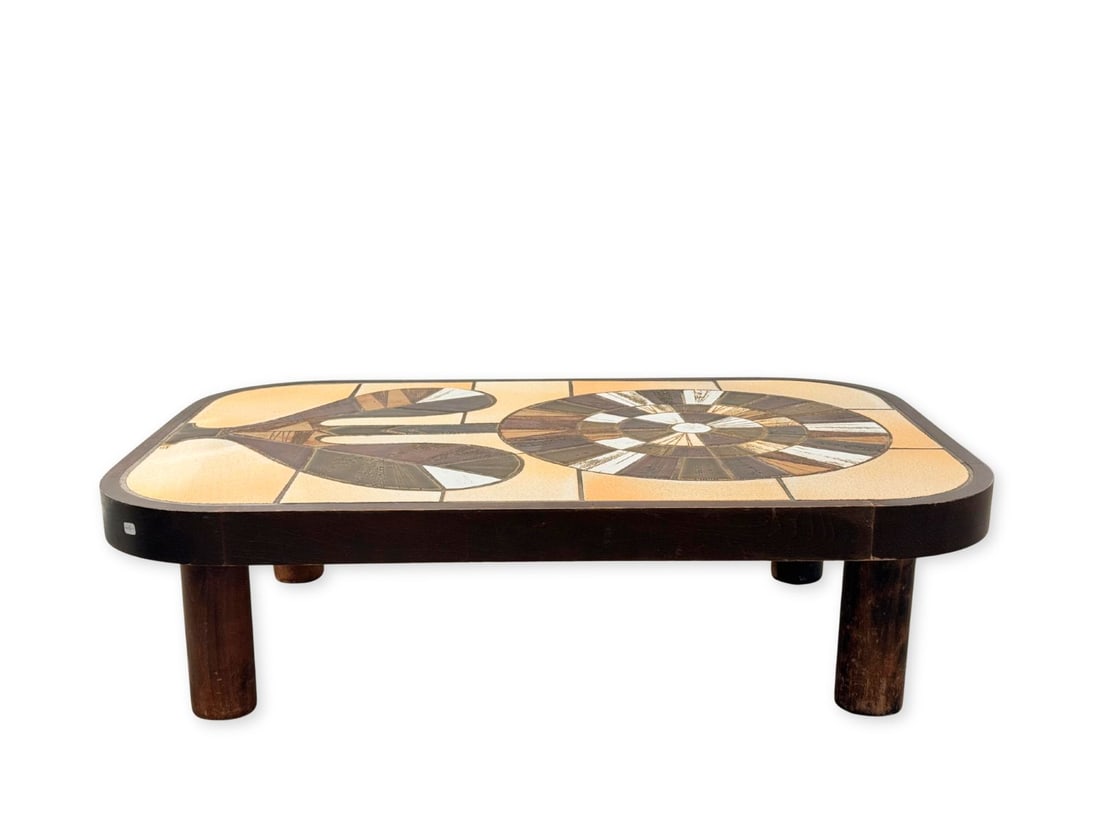 Roger CAPRON (1922-2006): Table basse modèle Zinn, circa 1975, à plateau rectangulaire aux bords arrondis composé de carreaux en grès polychrome à décor d'une fleur reposant sur quatre pieds de