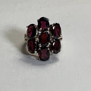 VINTAGE STERLING SILVER AND GARNET RING: Vintage sterling silver ring with seven garnets arranged in a flower cluster. Size 6