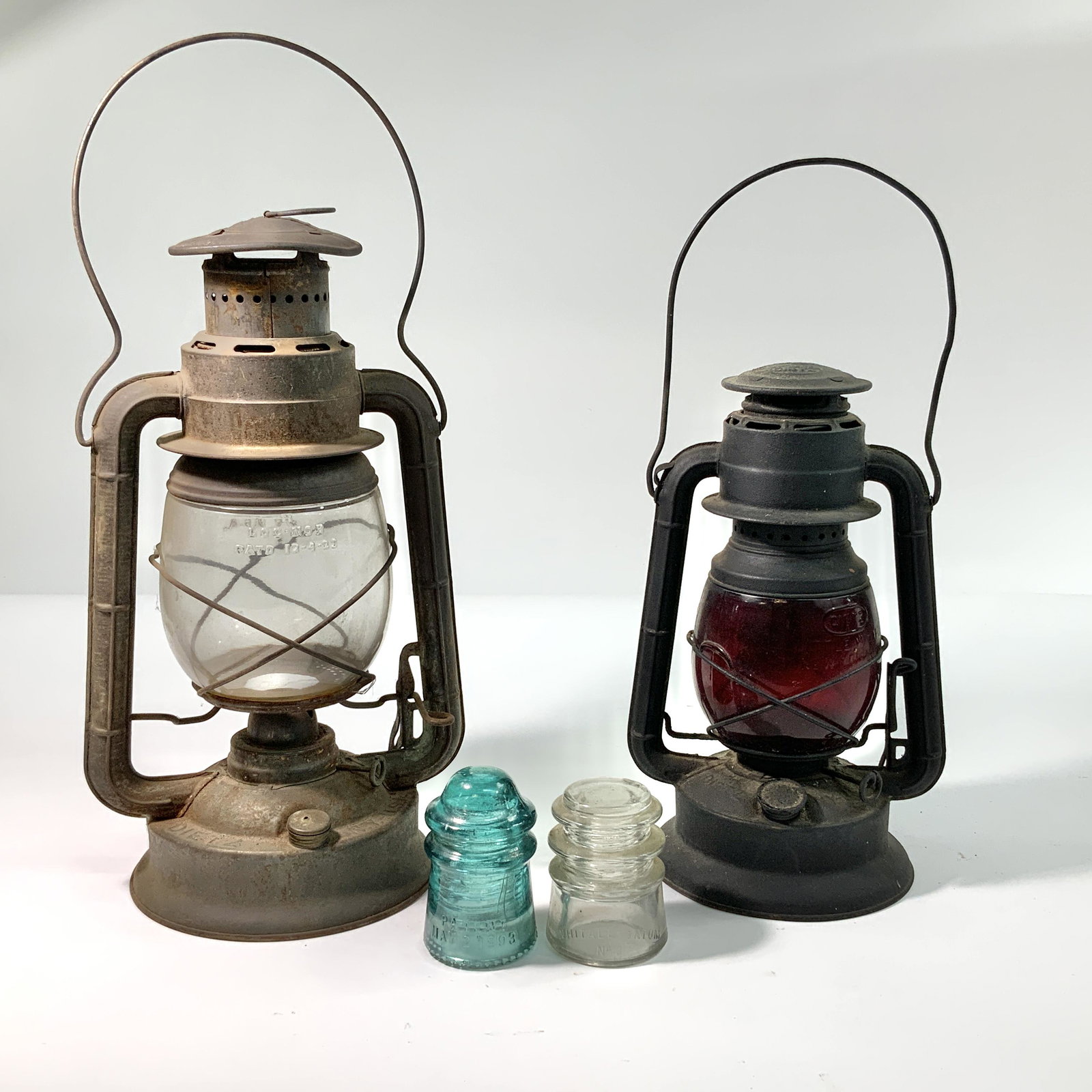 Kerosene Lanterns and Glass Insulators: Lot of two kerosene lanterns paired with two glass insulators.