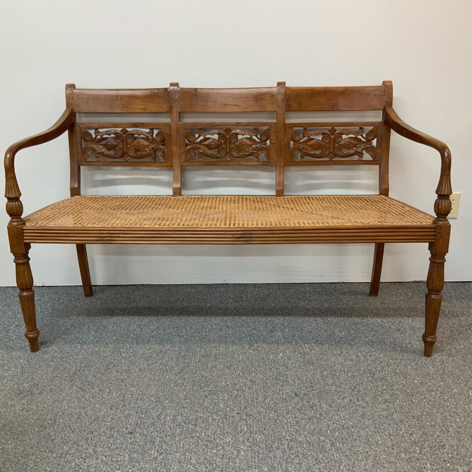 Carved Walnut Bench: Carved Walnut Bench with laced cane seat. Approx. 52 1/2" wide, 18" deep, and 33 1/4" tall.