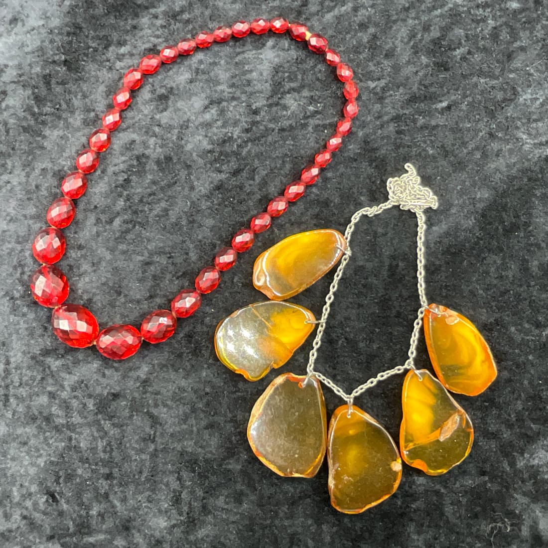 A Baltic Amber Necklace and Another Necklace: Baltic Amber Necklace, approx. 14" long. One is a chain with 6 amber drops, and the other is a choker style with reddish stones of unknown origin.