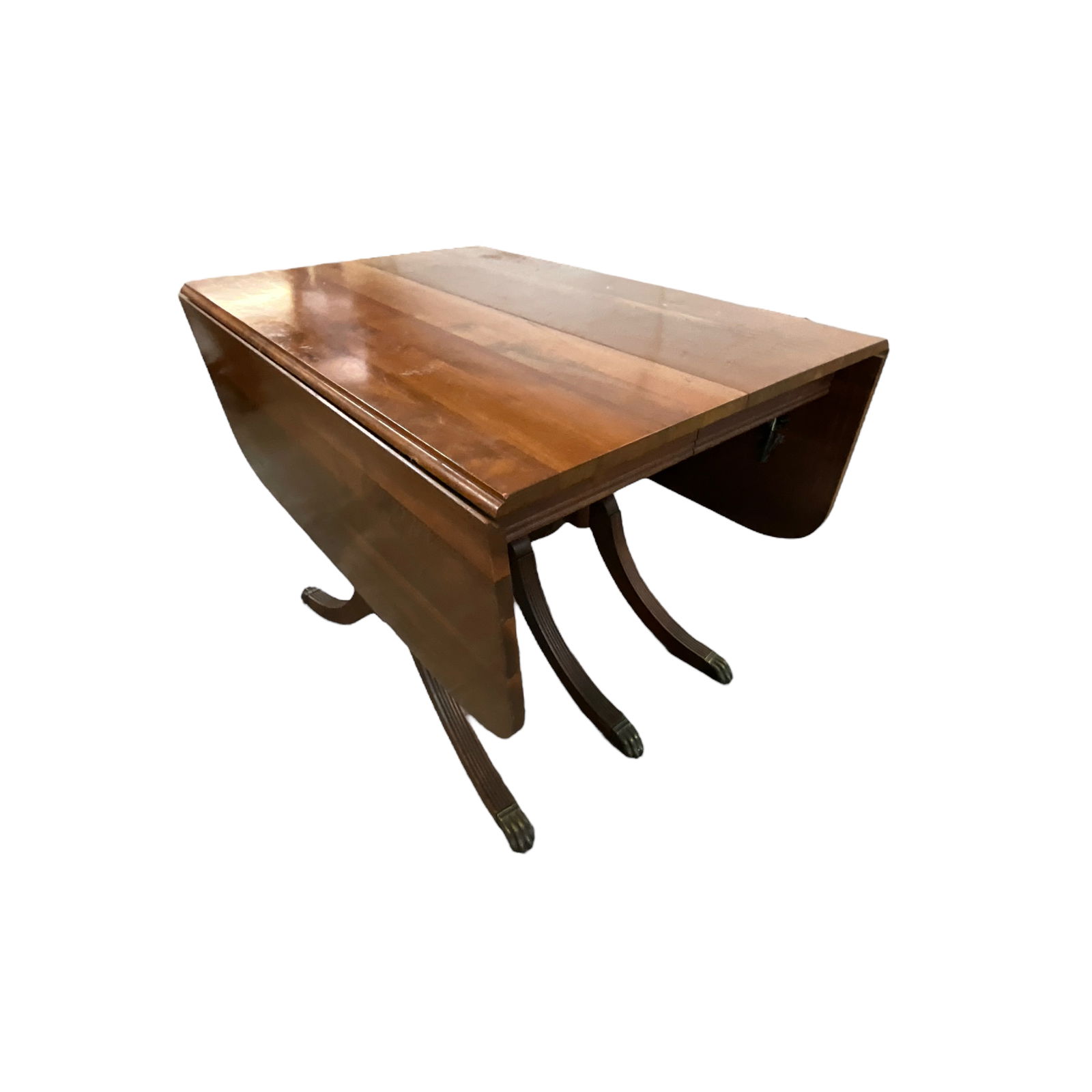 Drop Leaf Dining Table: Duncan Phyfe drop leaf dining table. Pedestal base with splayed and tapered legs with lion's paw brass feet. Approx. 28" by 40" when closed, 40" by 26" with leaves up. Approx. 29.75" tall.