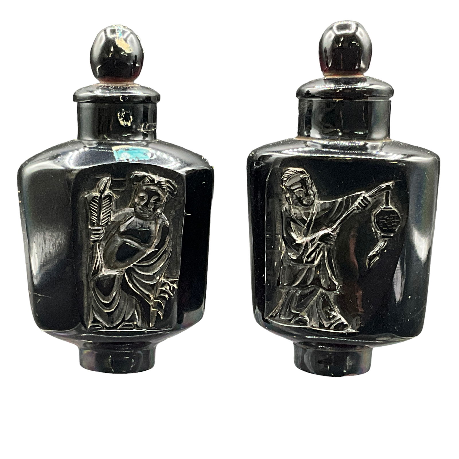 Chinese Obsidian Snuff Bottle Pair: Obsidian Snuff Bottle pair. Bottles feature raised image on one side and etching on reverse. Each approx. 3 1/2” long.