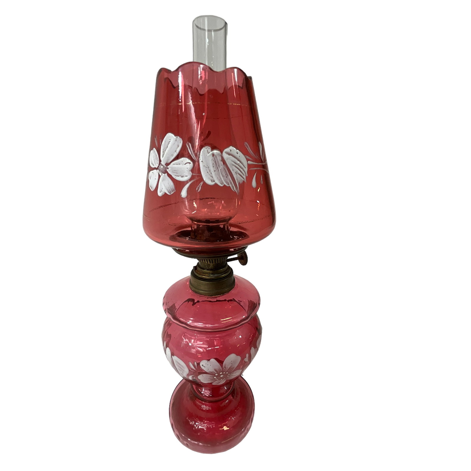Miniature Victorian Oil Lamp, Cranberry Glass with White Enamel Floral Design: Cranberry glass oil lamp featuring painted white enamel flowers/leaves. Includes base, shade, chimney, and burner. Measures approx. 10 1/2" tall, 3 1/4" diameter.