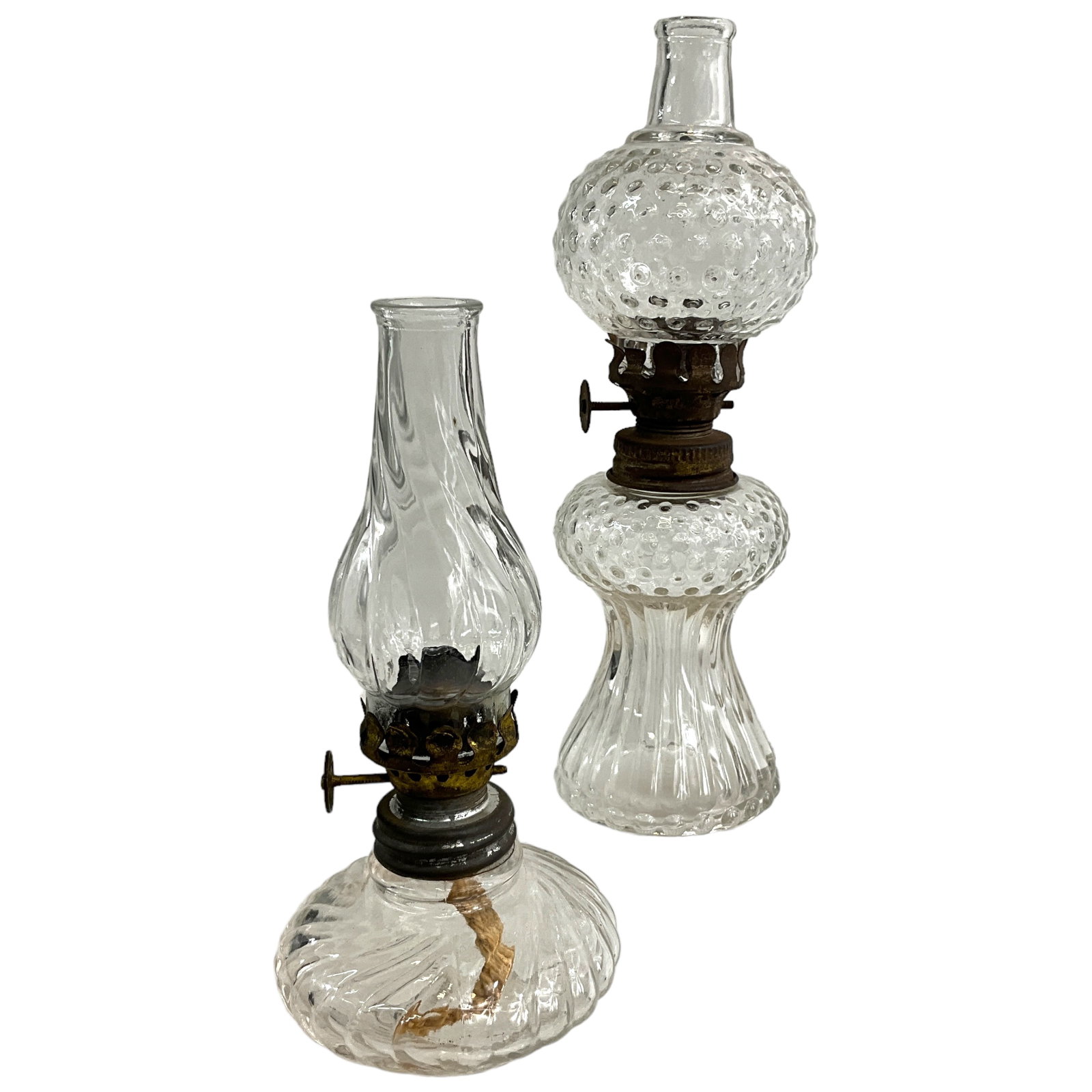 Miniature Victorian Oil Lamps, Clear Glass, Embossed Designs: Miniature victorian oil lamps in clear glass (lot of 2), each featuring a different ribbed design; each with matching embossed chimney. Includes bases, chimneys, and burners. Tallest lamp measures app