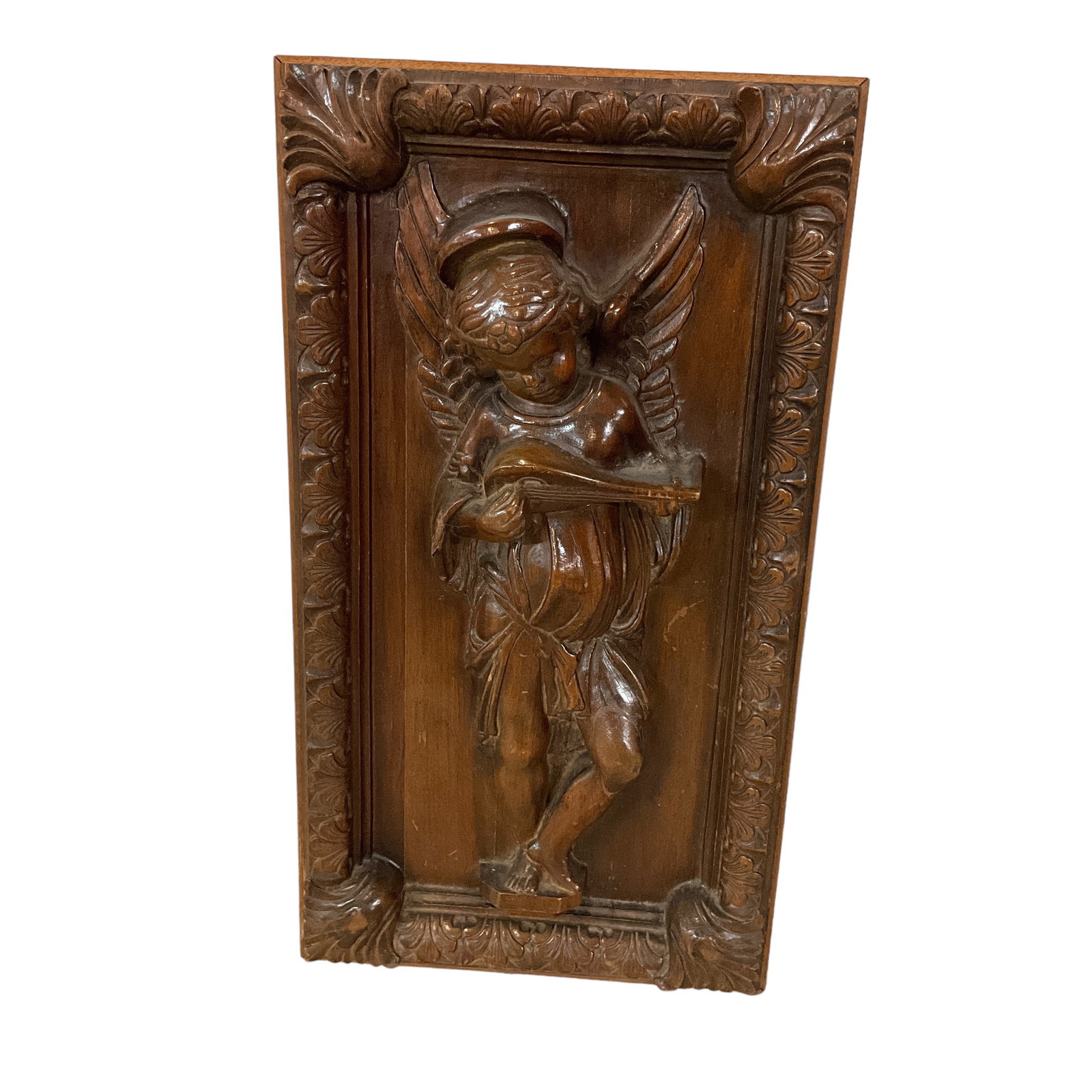 Renaissance Revival Cherub Carved Panel: A Renaissance Revival deeply carved walnut cherub panel, likely salvaged from a piece of furniture. Carving depicts a cherub playing a lute, with an acanthus carved border with fan corners. Approx. 25