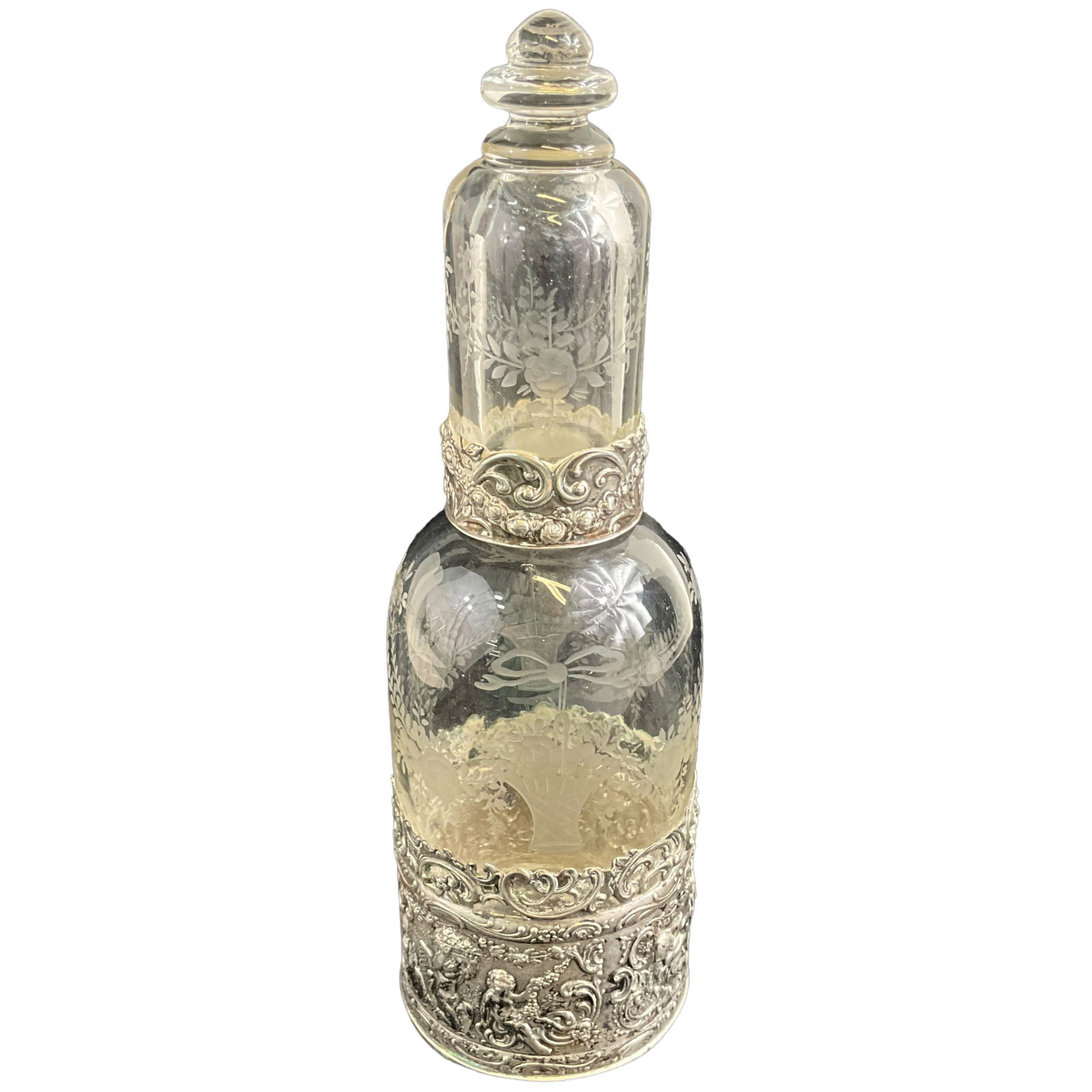 Dutch Sterling Silver Ornamental Decanter: Dutch etched glass bottle with ornamental sterling silver sleeve. Several hallmarks on the bottom. Measures approx 8" tall, 2.5" wide OA.