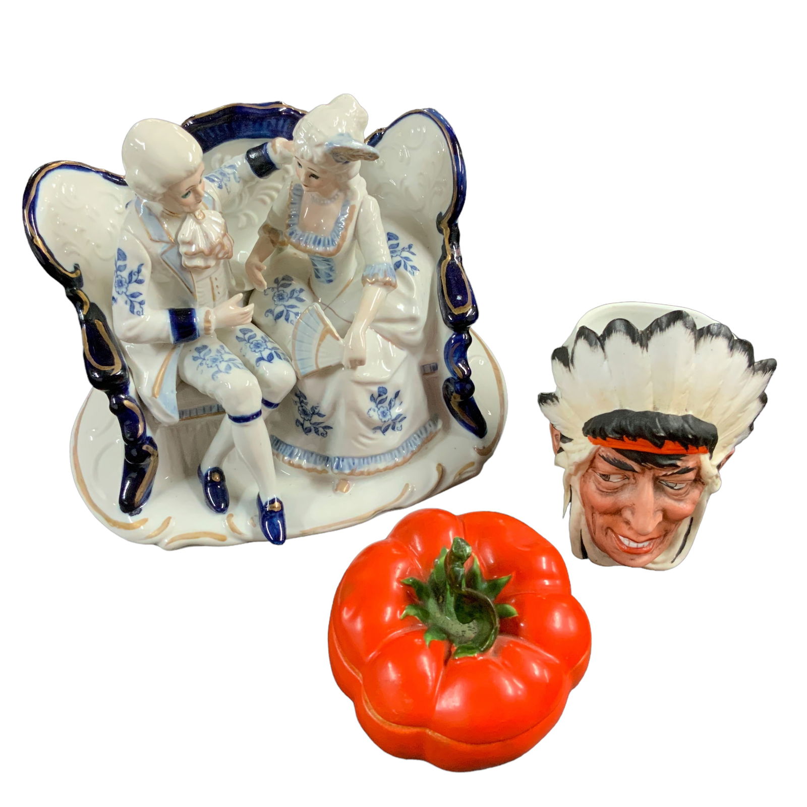 Figural Pieces, Lot of 3: Lot includes dating couple figurine, Indian planter, and Royal Bayreuth tomato-shape covered dish. Figurine measures approx. 6 1/2" tall, 8 1/2" wide, 6 1/4" deep. Tomato measures approx. 3 1/2" tall,