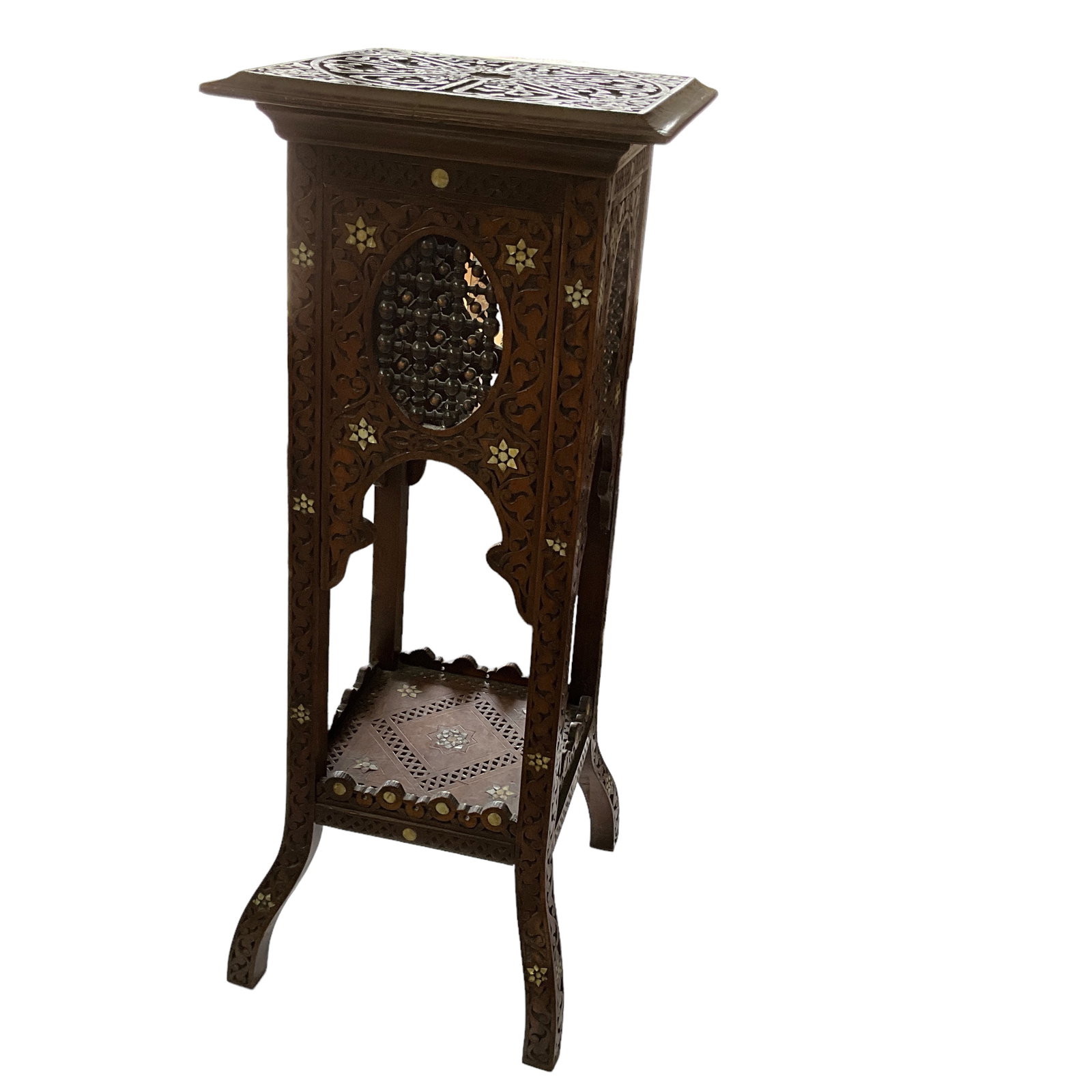 Carved Wood Stand w/Inlaid Mother of Pearl: Carved wood stand/table with mother of pearl inlay, turned wood accents, arched aprons and undershelf, and metal; decorated with geometric, star, and foliate motifs. Some inlay pieces are missing, inc