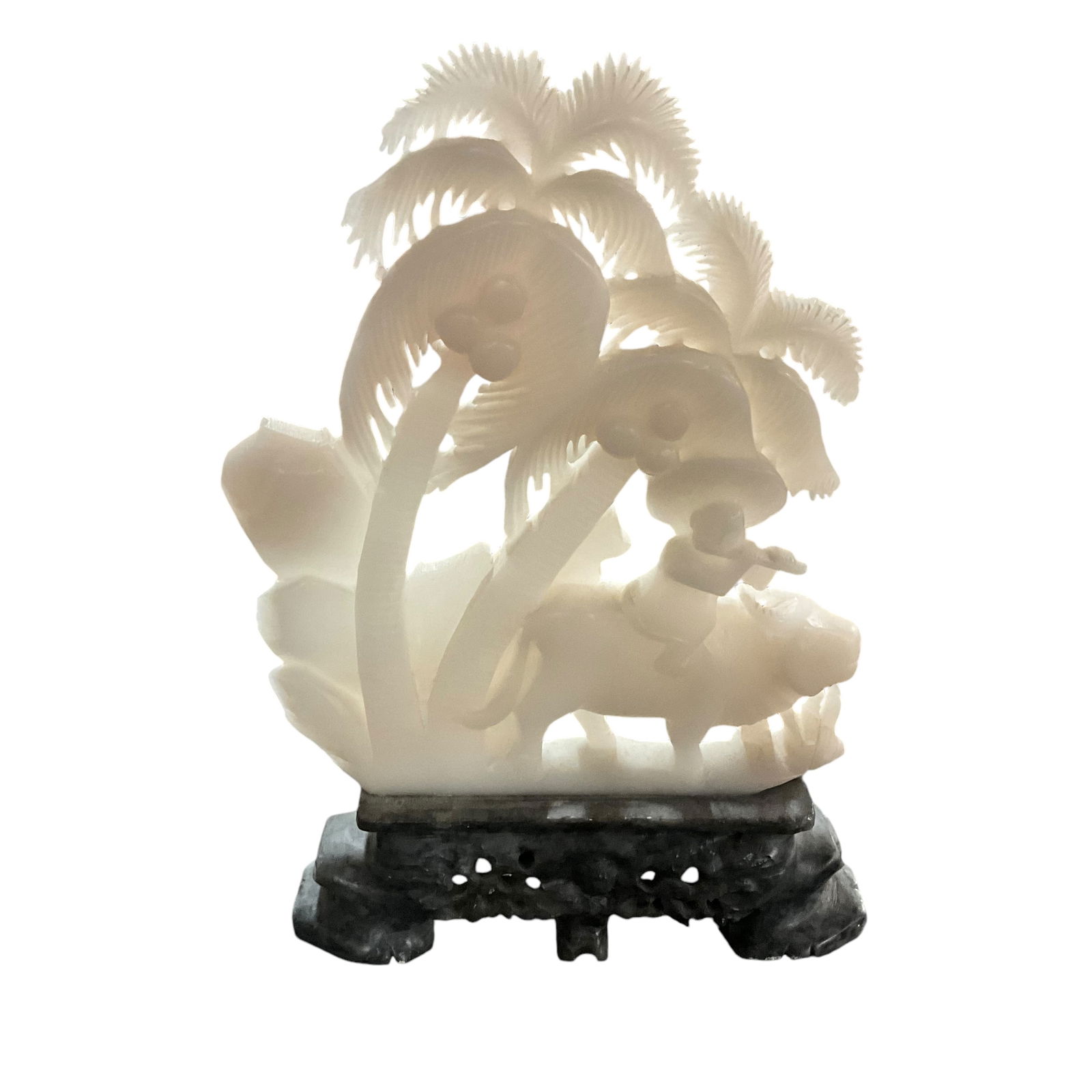 White Jade Sculpture on a Soapstone Base: White Jade Sculpture on a Soapstone Base- Sculpture depicts a a man playing a flute while riding a water buffalo under coconut palms. This piece measures approx. 14.5" Tall, 10" wide, and 2" deep.