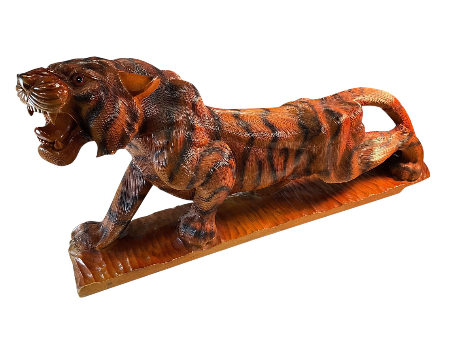 Carved Tiger Figure: Carved Tiger Figure- large format tiger carving, approx. 42"long, of a crouching, snarling tiger. Painted wood with glass eyes (one has a slight crack). A statement piece.