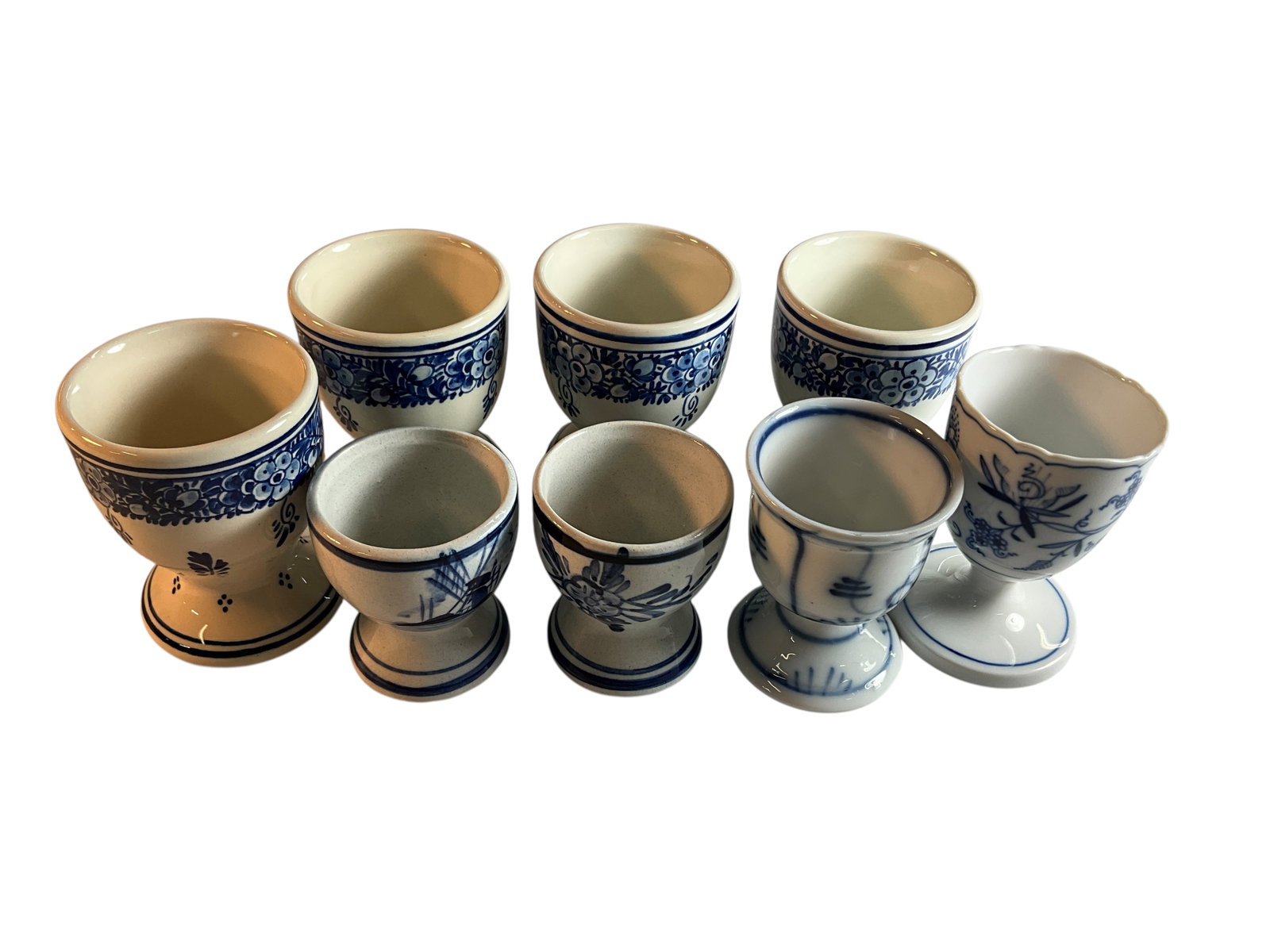 Delft & Meissen Egg Cups: Delft & Meissen Egg Cups- set of four Delft marked Egg Cups, approx. 3" high, a single Meissen egg cup with crossed swords mark, approx. 3" high. There is also a pair marked "Hand Painted in Delft's B