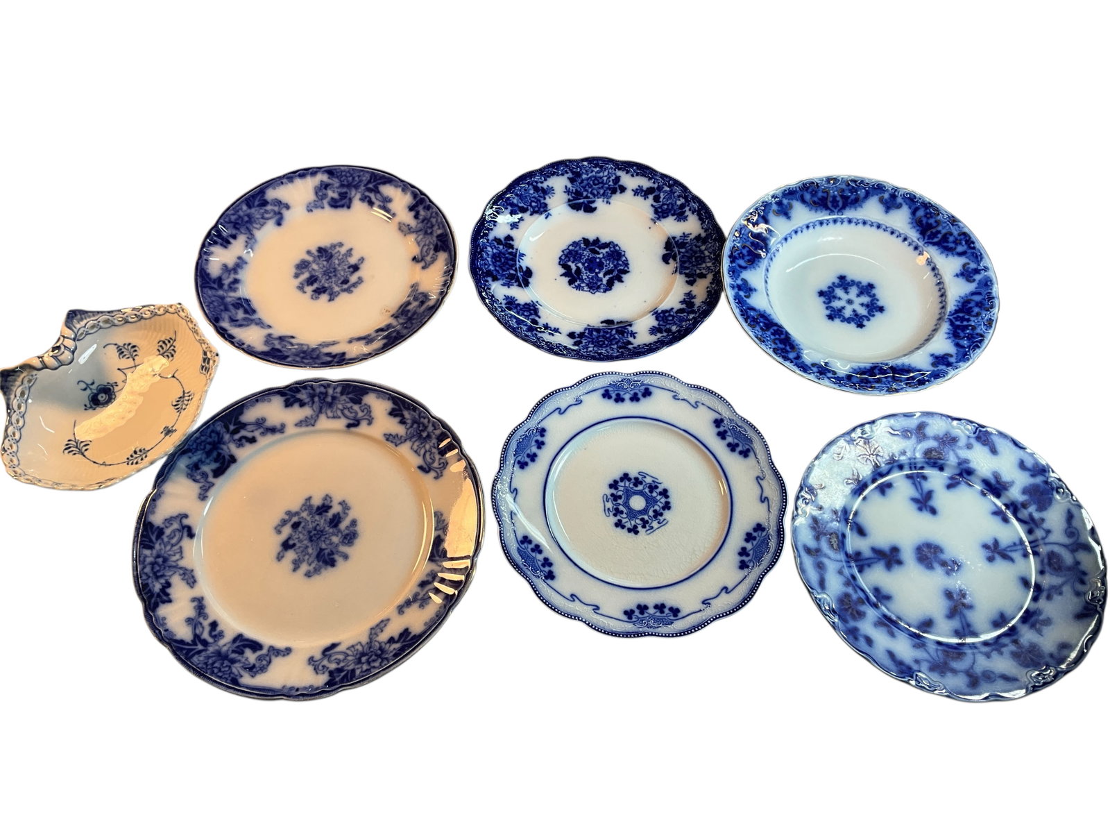 Group of Flow Blue Plates & Dishes: Group of Flow Blue Plates & Dishes. A Royal Copenhagen Shell Dish, an Albany soup bowl, and five dinner plates with makers including Colonial, Lorne, and Thos. Hughes & Son,.