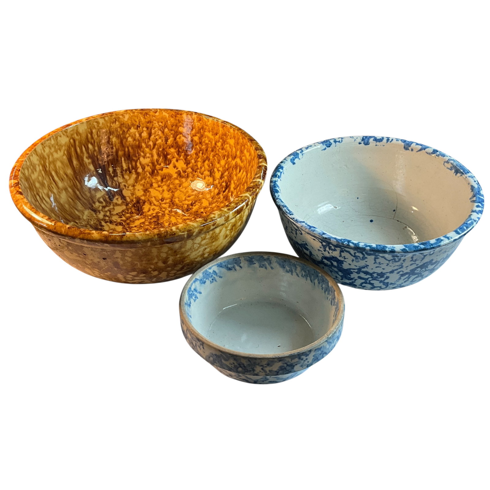 Trio of Spongeware Bowls: Trio of Spongeware Bowls. A brown spongeware bowl, 12.5" in diameter, and two smaller blue spongeware bowls, 10.25" and 7.25" in diameter.