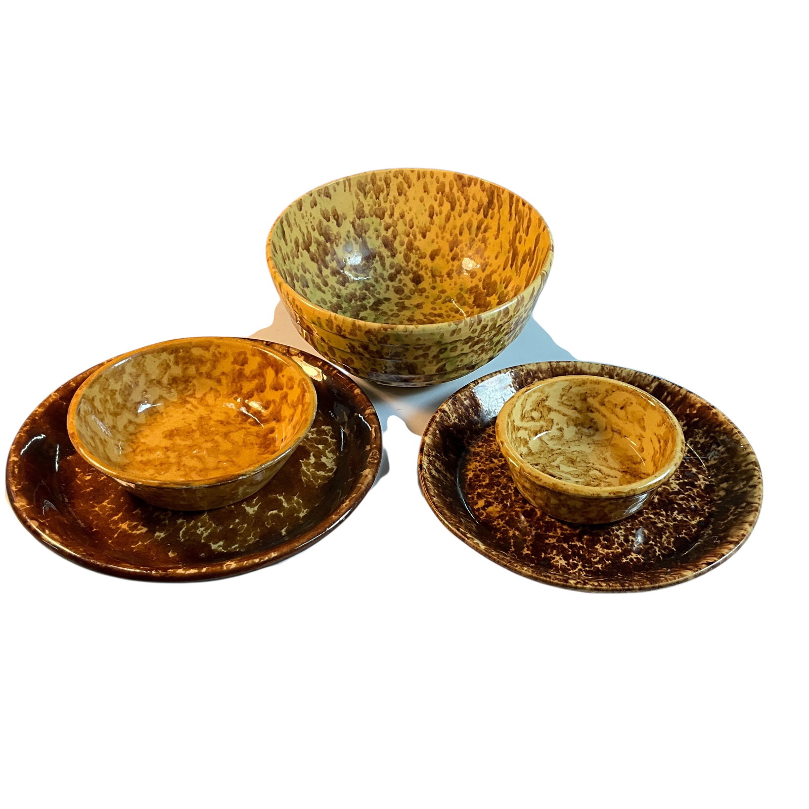 Lot of Five Spongeware Dishes: Lot of Five Spongeware Dishes. One 9.75" and one 10.75" pie pans, a 9.5" mixing bowl, and two smaller bowls- one 7" and one 5". All in shades of tan and brown.