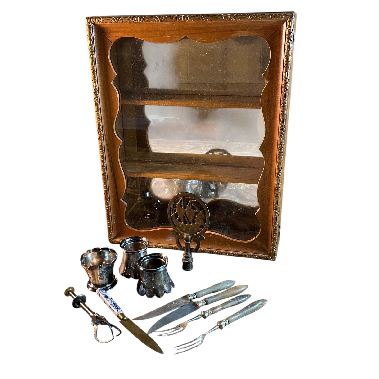 Display Case with Smalls: Display Case with Smalls. Small wall hung display case with mirrored back and two fixed shelves. Smalls include 3 silver plate napkin rings, a lamp finial, and misc. flatware with handles of wood or d