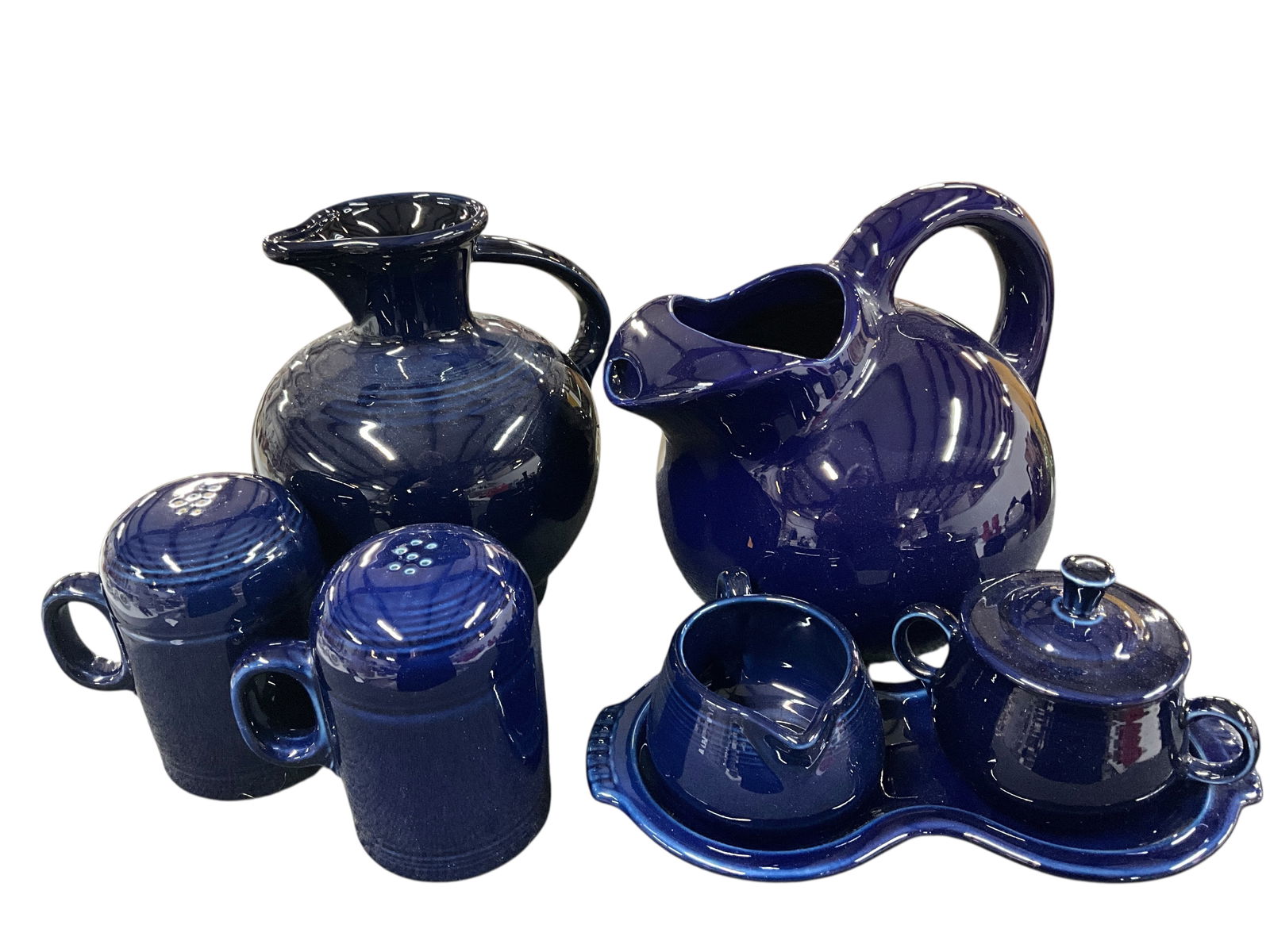Fiestaware Grouping, Cobalt Blue Colorway: Fiestaware Grouping, Cobalt Blue Colorway. The Cobalt colorway was produced from 1986-2021. This group consists of an 8" Round and an 8" urn pitcher, Rangetop salt & pepper shakers, and a figure 8 und