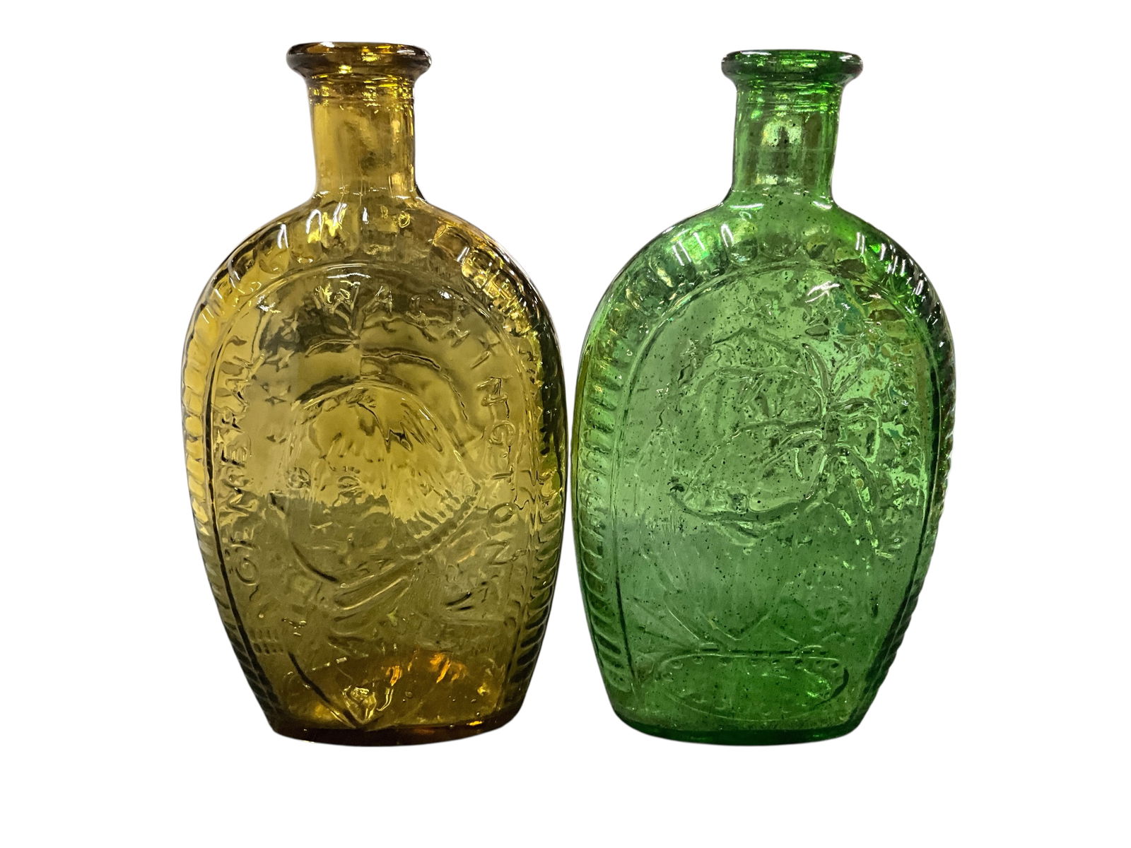 Pair of Wheaton or Imperial George Washington Reproduction Bottles: Pair of Wheaton or Imperial George Washington Reproduction Bottles. Likely made in the 1970's for the US Bicentennial. One in amber and one in green, they each feature George Washington on one side,