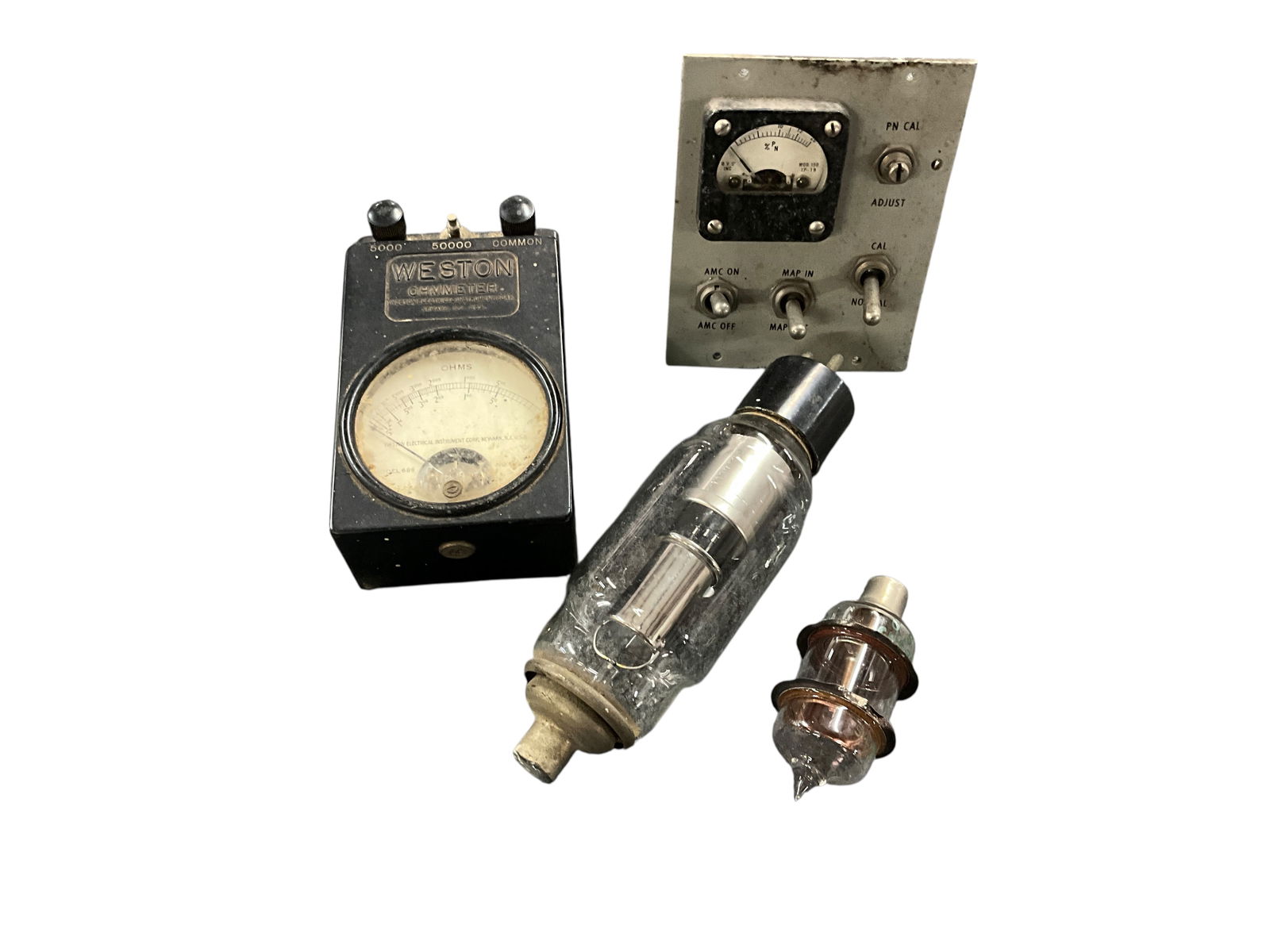 Vintage Electronic Components: Vintage Electronic Components. A Weston Ohmmeter, a small panel with toggle switches and a gauge, likely used for calibrating avionics units, and two old radio vacuum tubes, one of which is nearly 7"